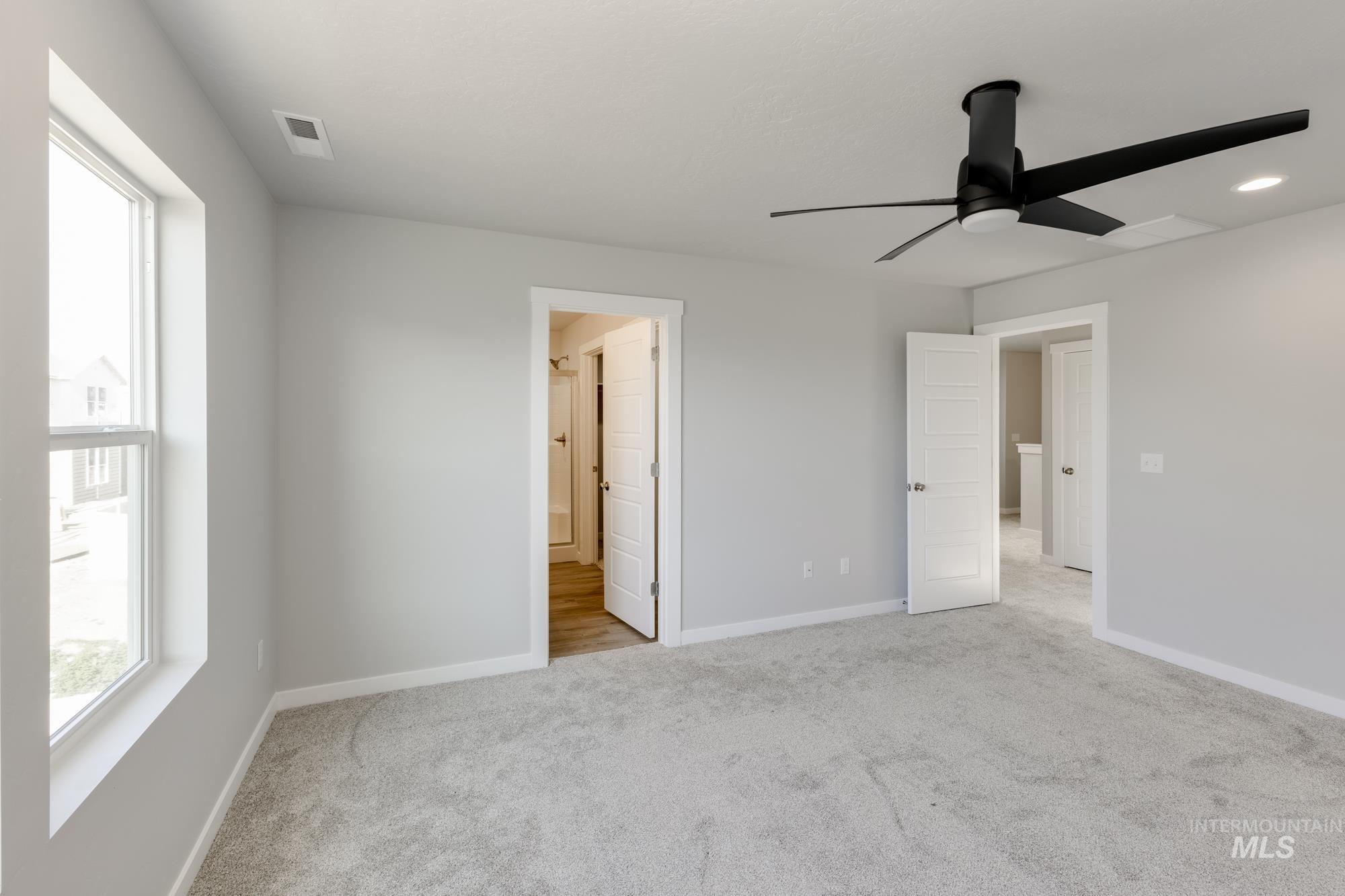 Unfurnished bedroom with light colored carpet, a ceiling fan, ensuite bath, and recessed lighting