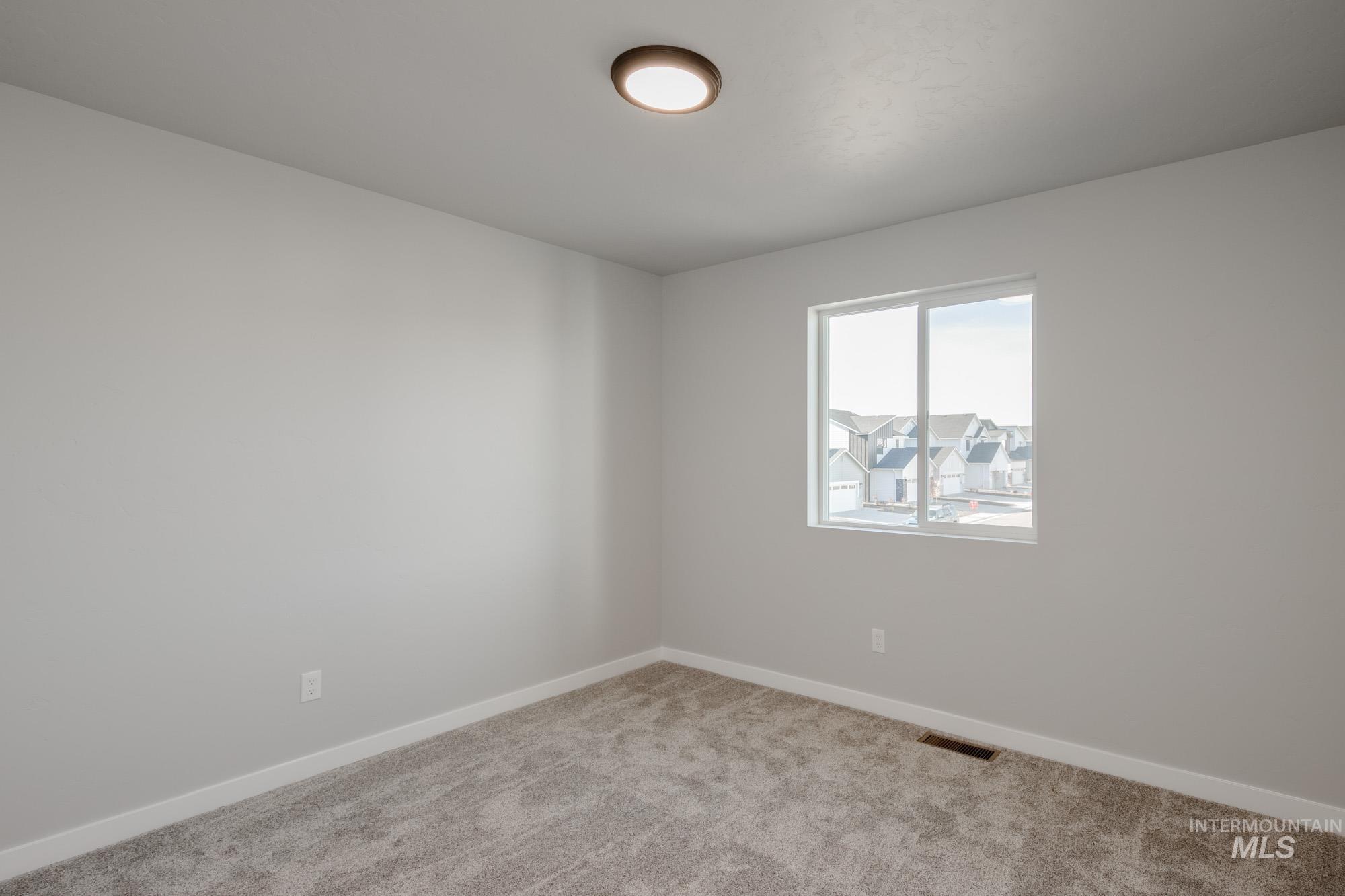 Carpeted empty room with baseboards