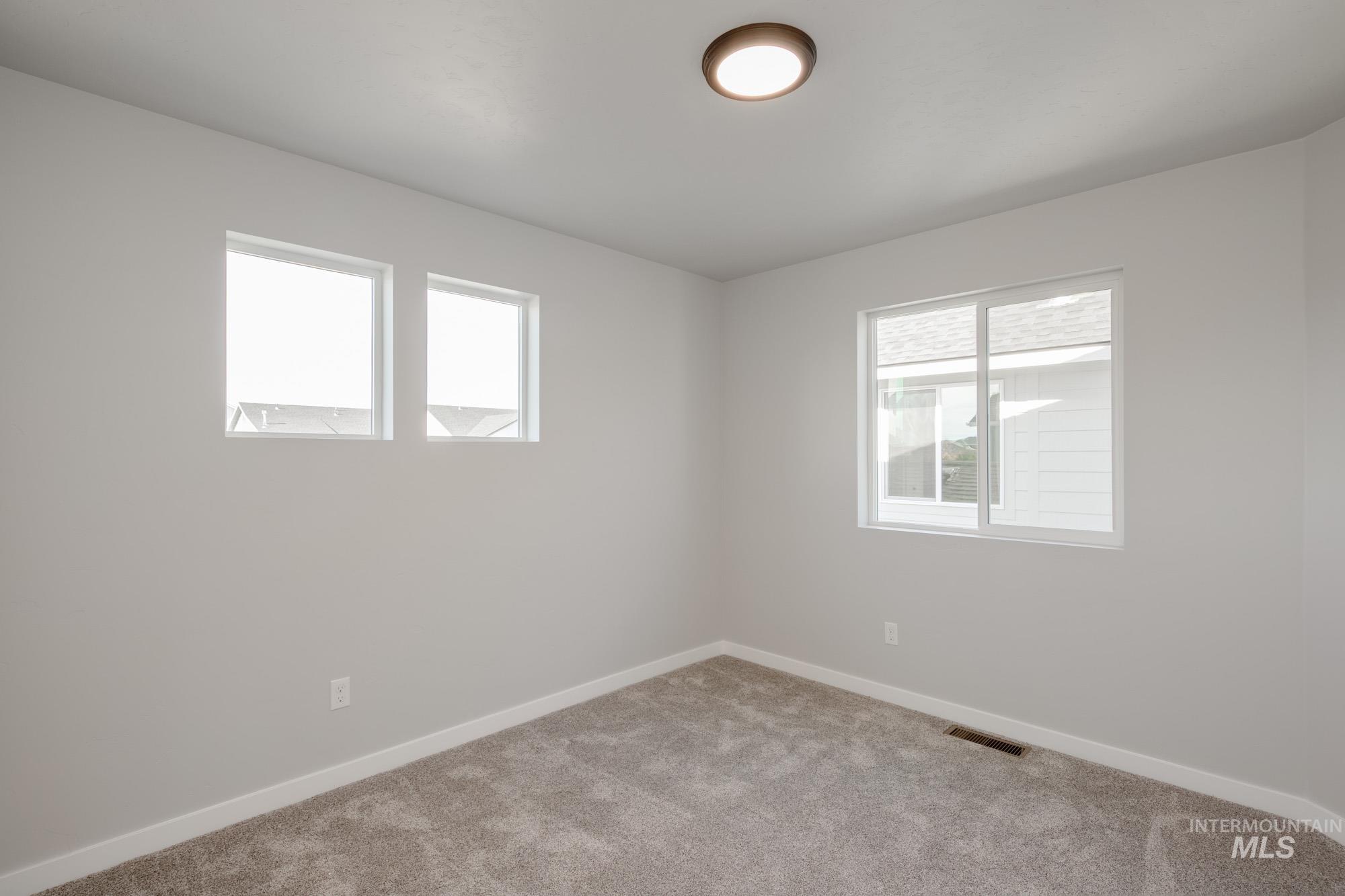 Carpeted spare room with baseboards