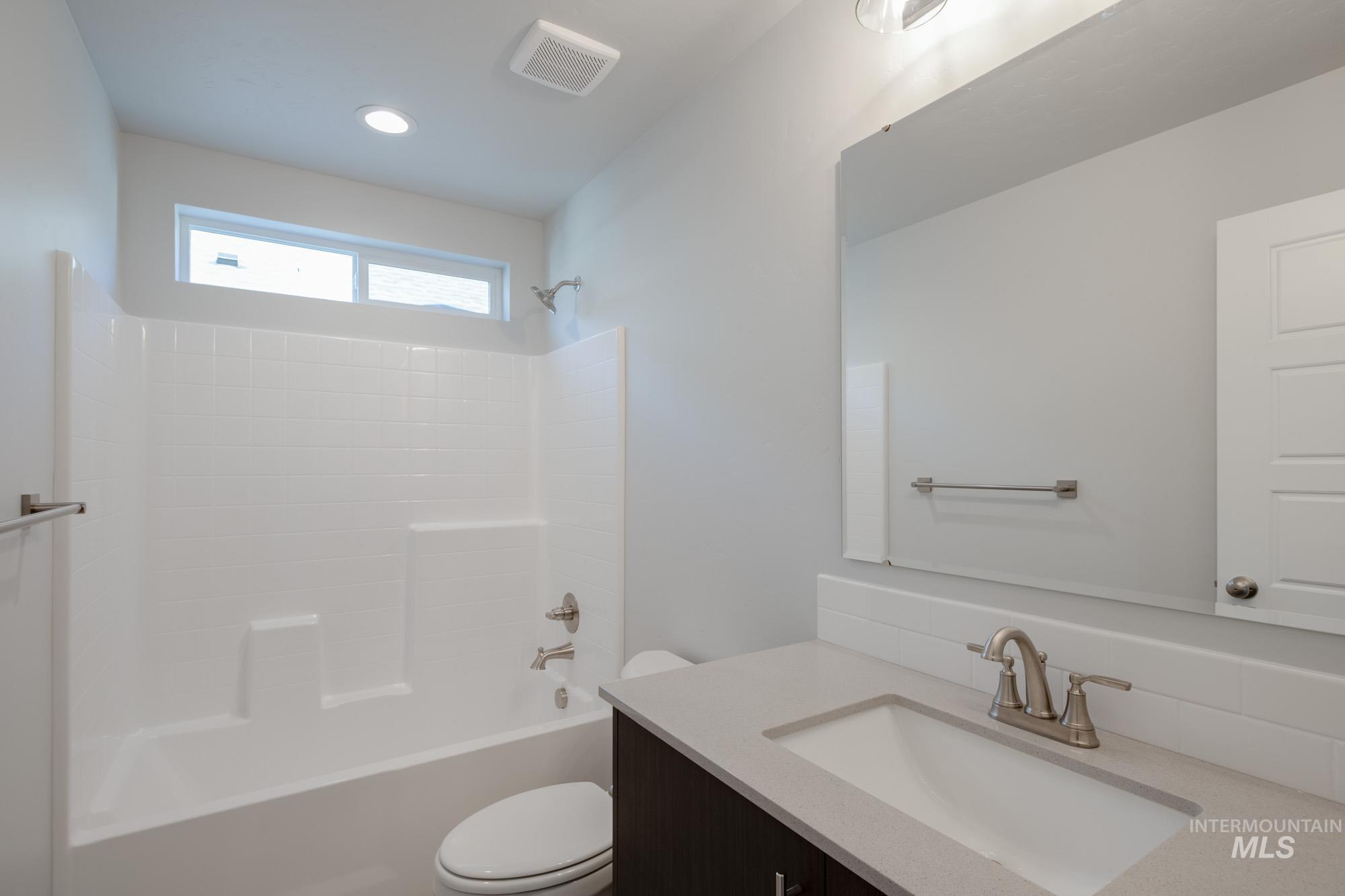 Full bathroom with vanity, shower / bath combination, and recessed lighting