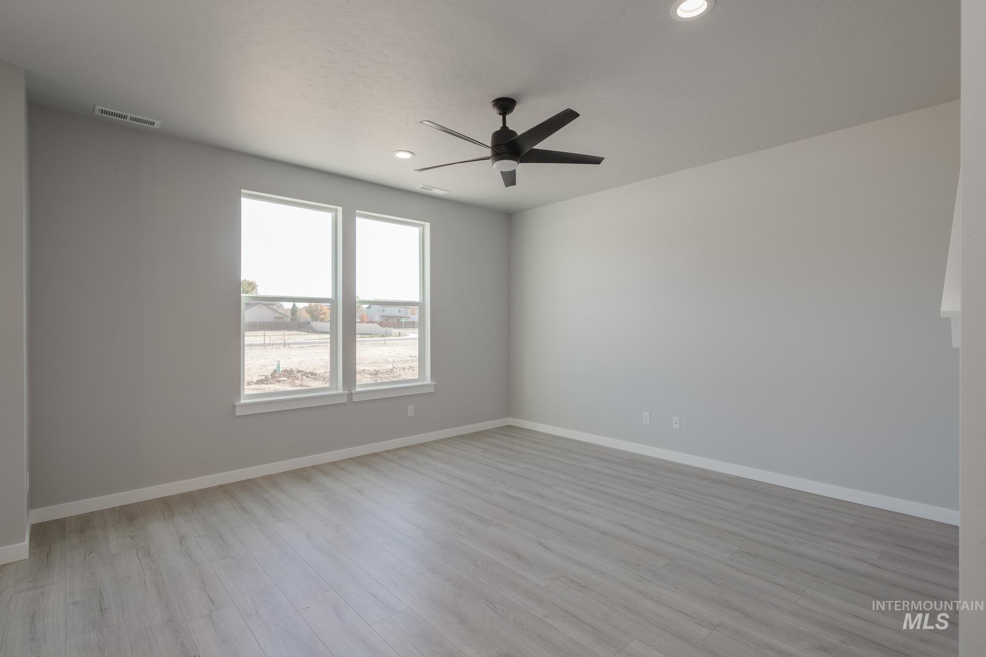 Empty room with light wood-style flooring, recessed lighting, and a ceiling fan