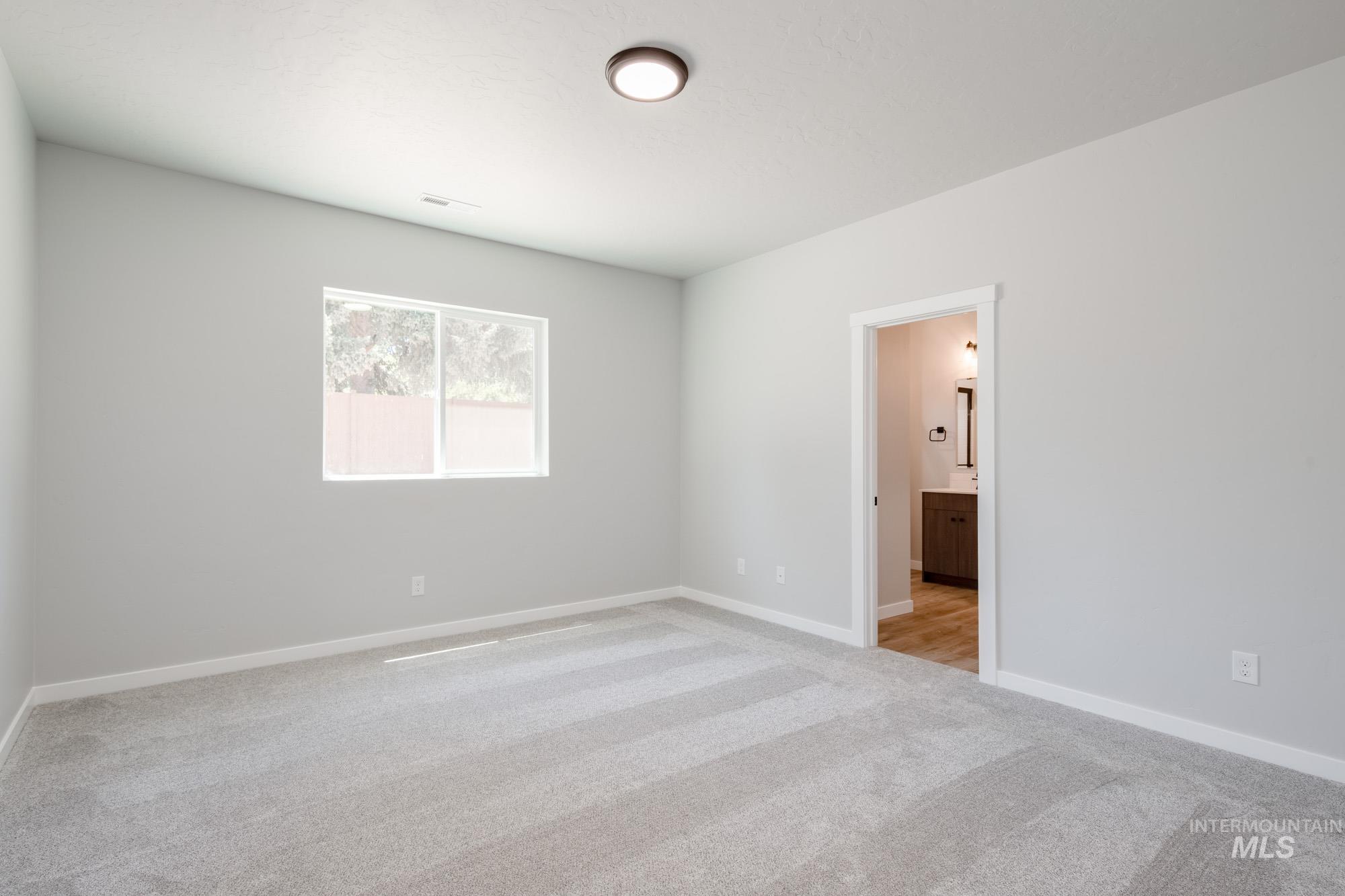 Empty room featuring light carpet and baseboards