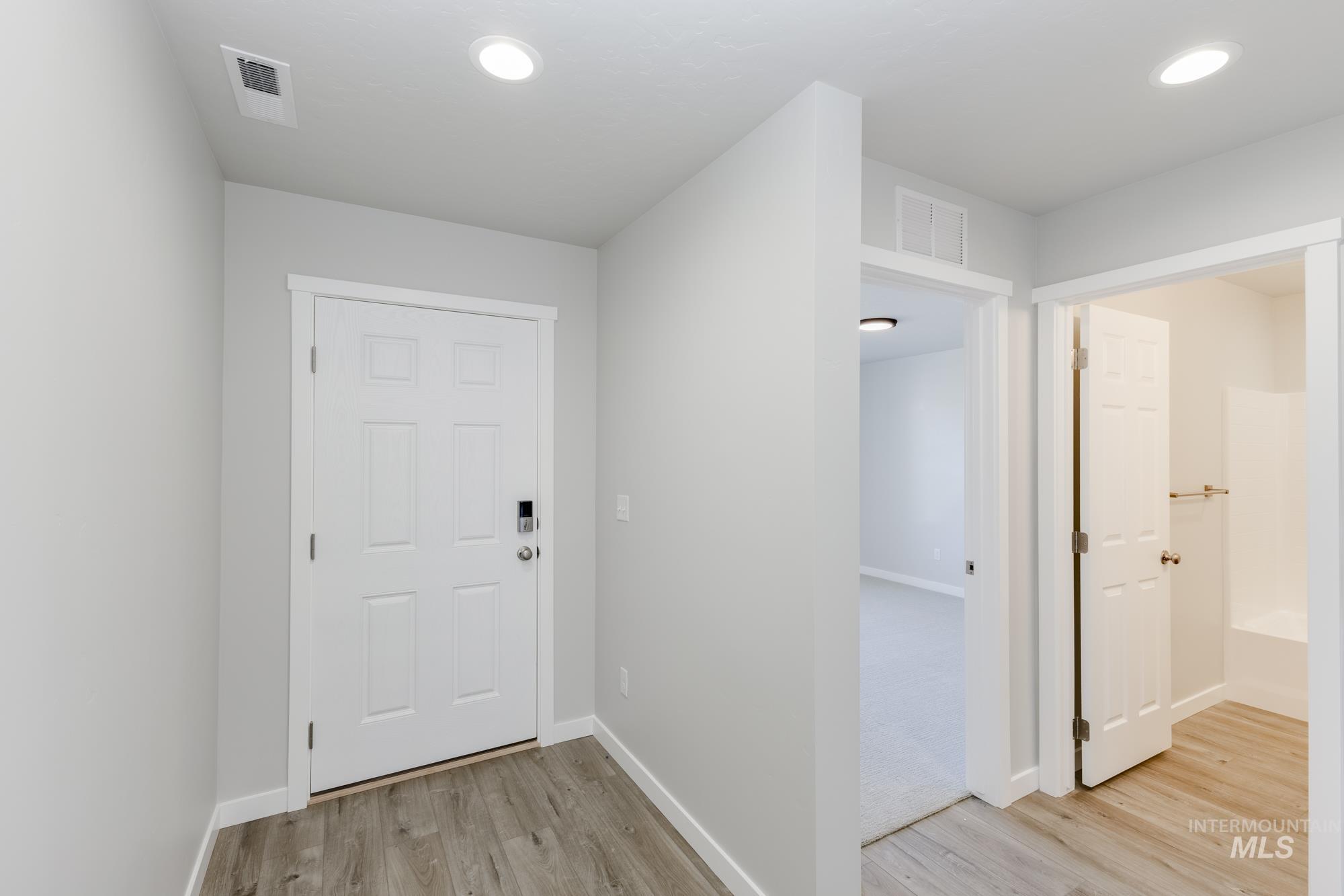 Hallway featuring light wood-style flooring and baseboards