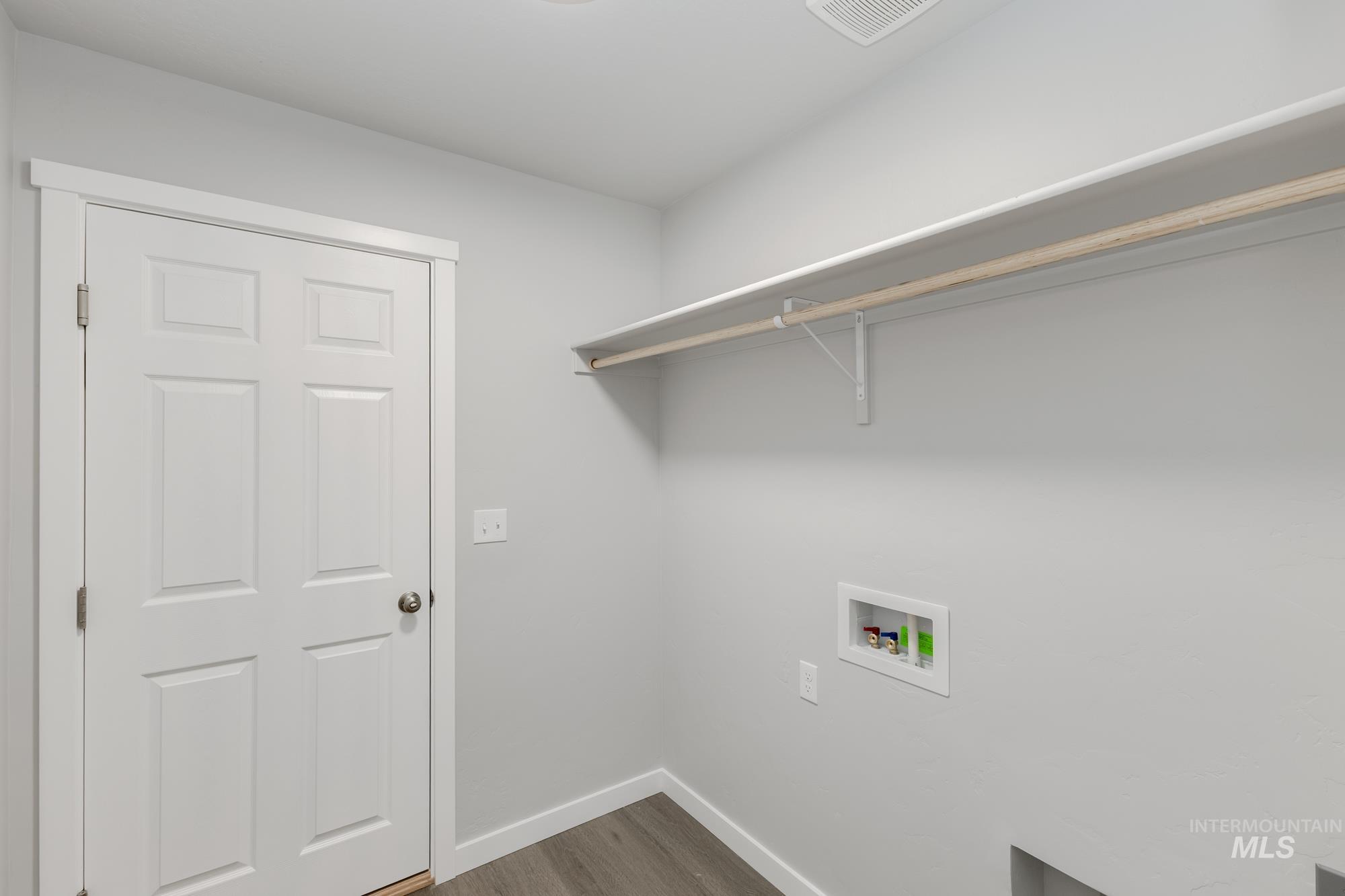 Laundry room with dark wood finished floors and hookup for a washing machine