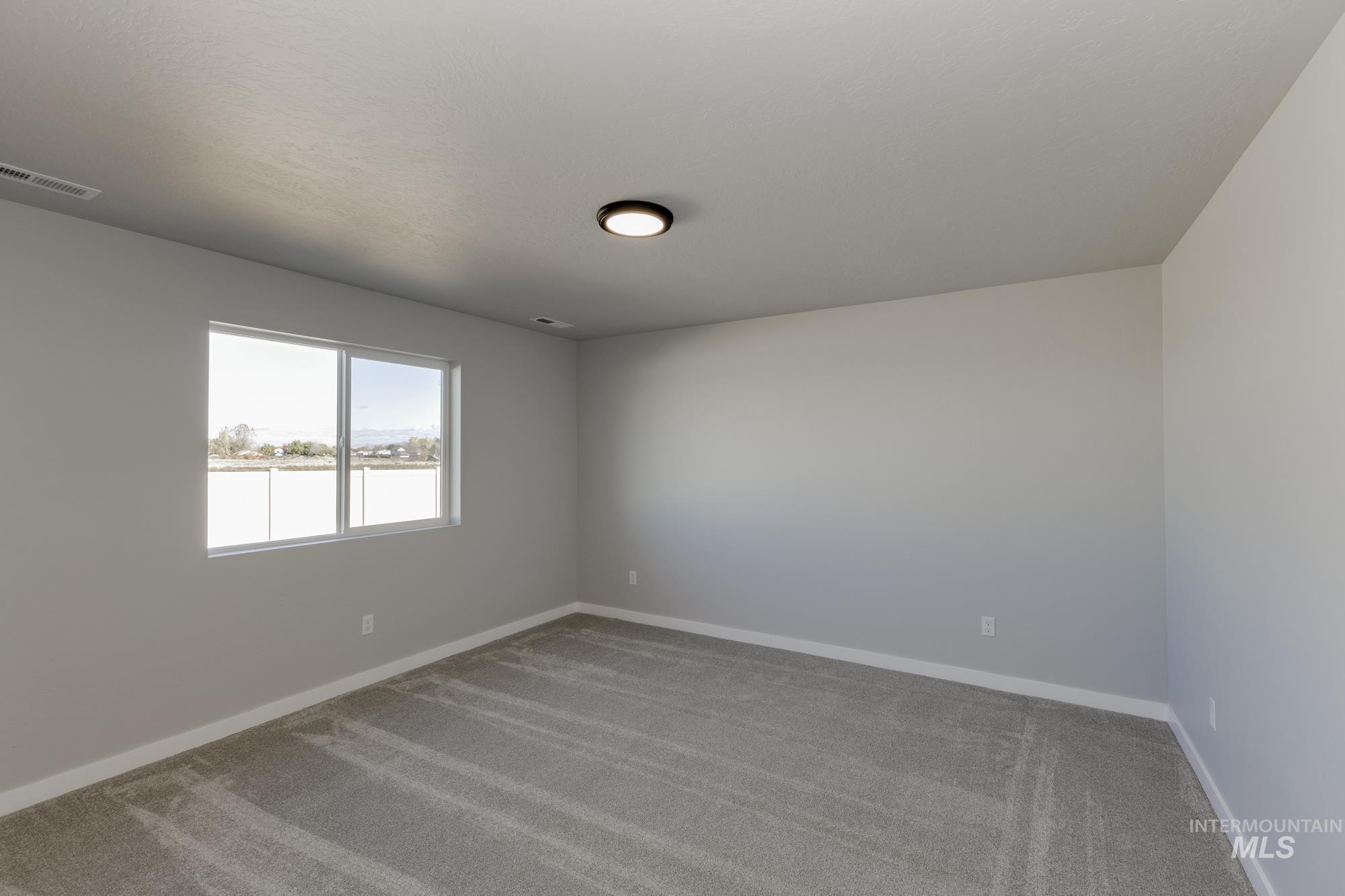 Carpeted empty room with baseboards