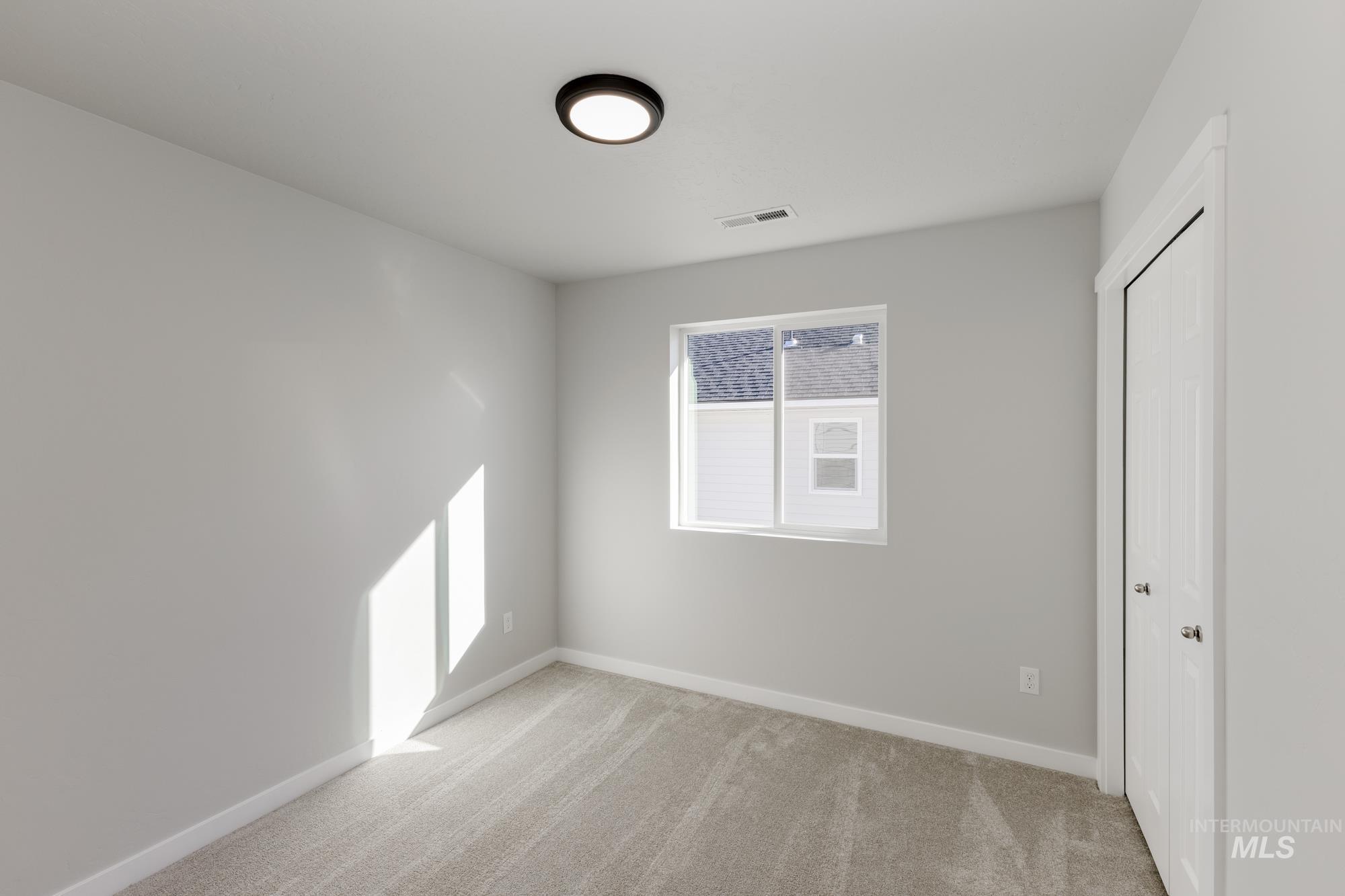 Unfurnished bedroom with light carpet and a closet