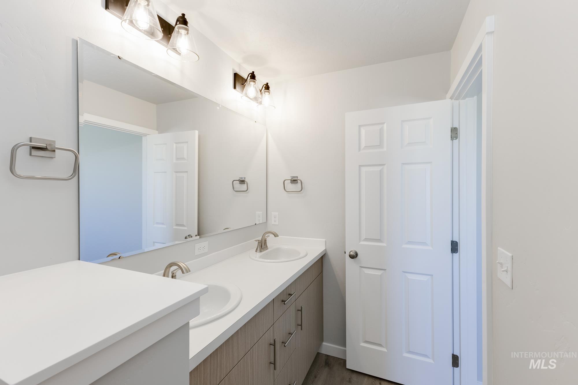Bathroom featuring double vanity and wood finished floors