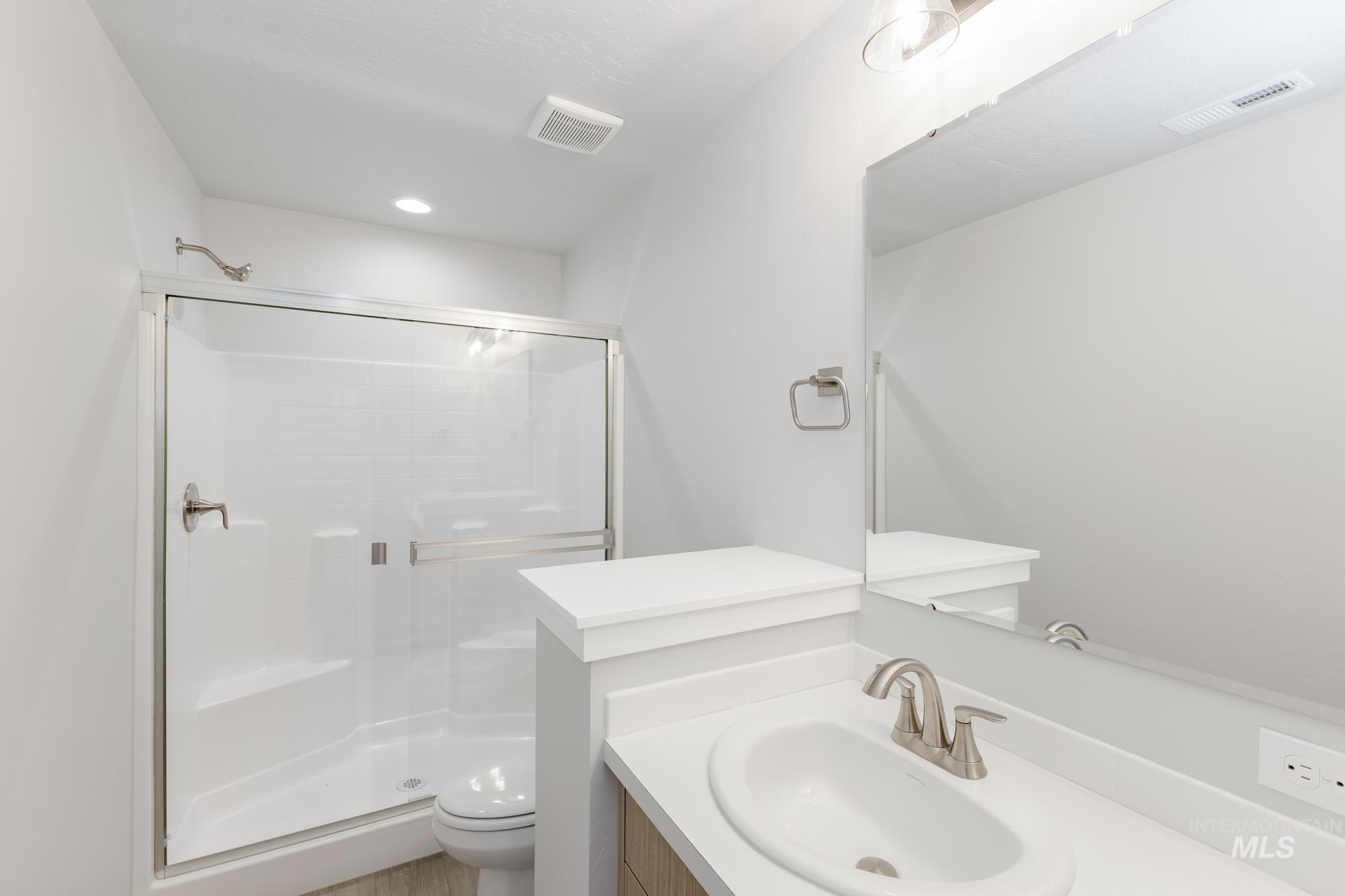 Full bathroom featuring vanity, a shower stall, and recessed lighting
