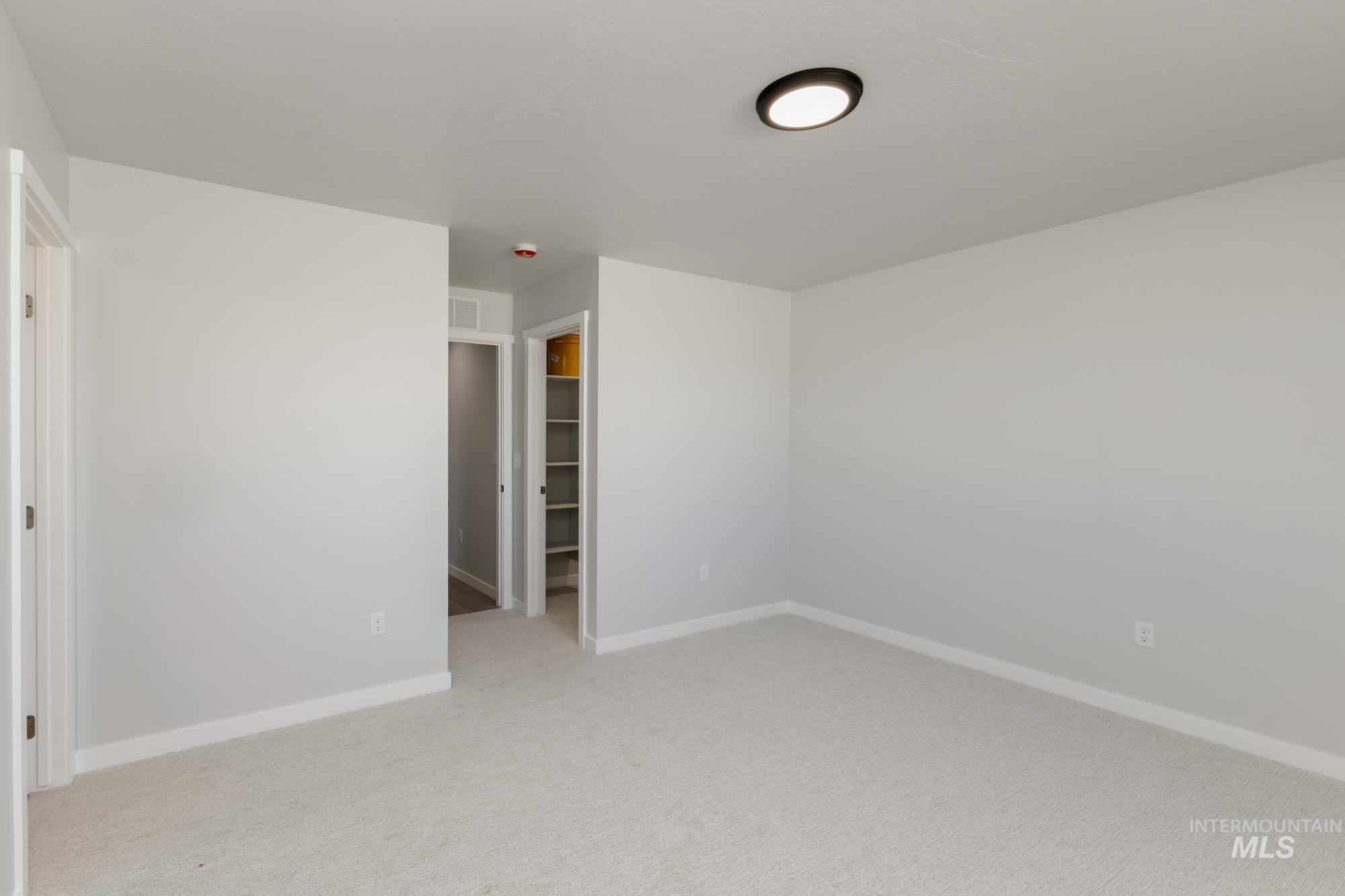 Spare room featuring baseboards and light carpet
