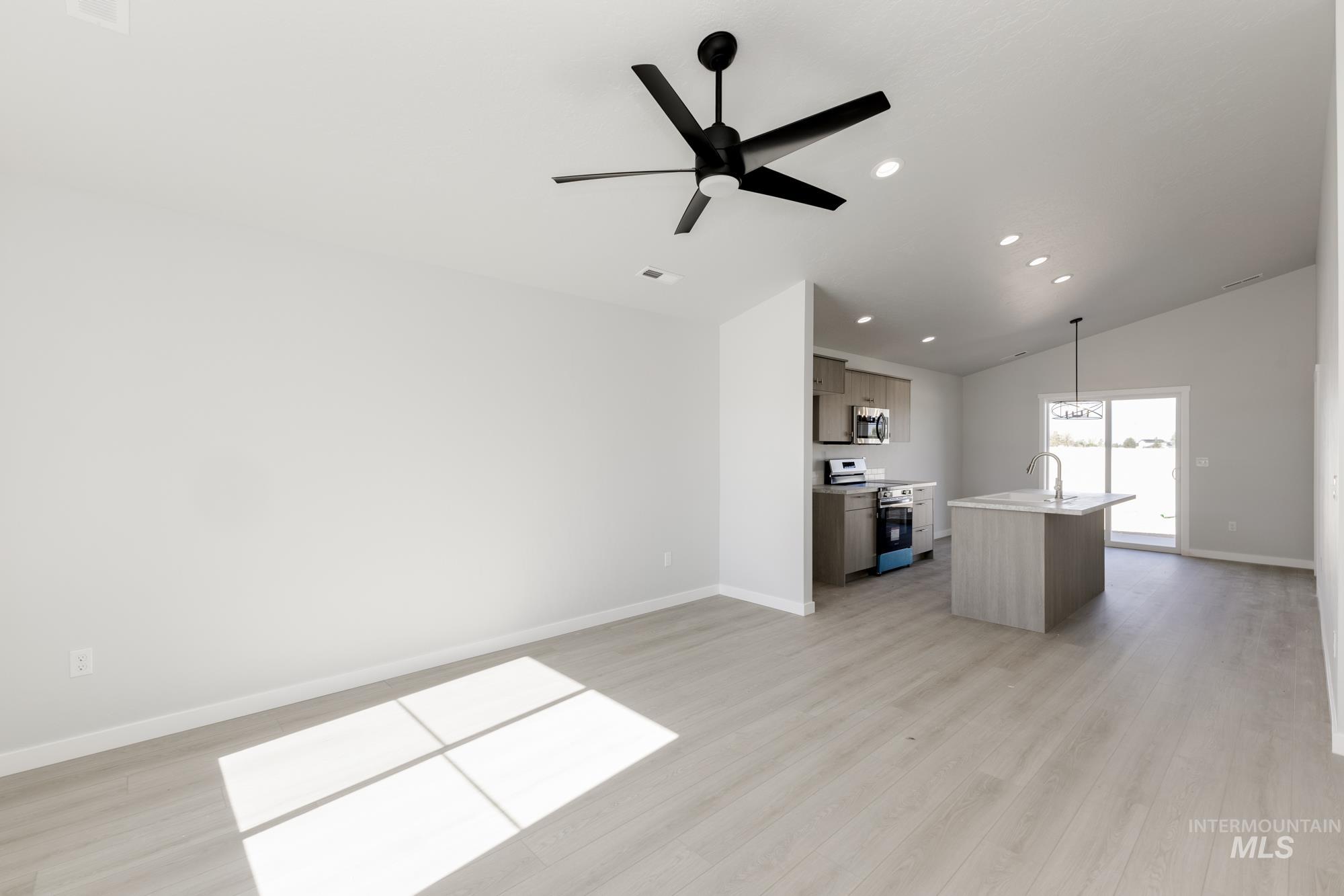 Unfurnished living room with light wood-style flooring, recessed lighting, a ceiling fan, and lofted ceiling