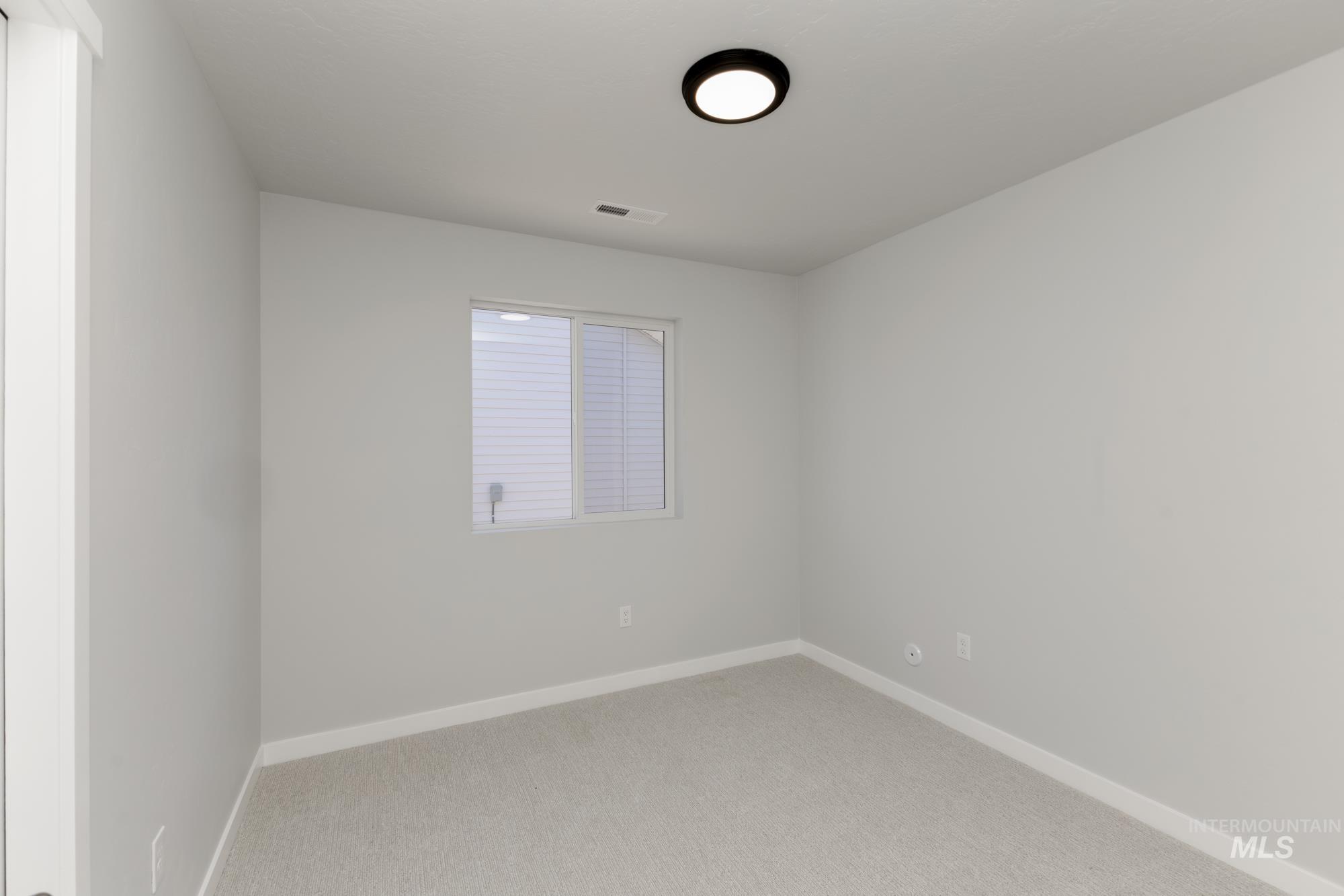 Spare room featuring baseboards and light colored carpet