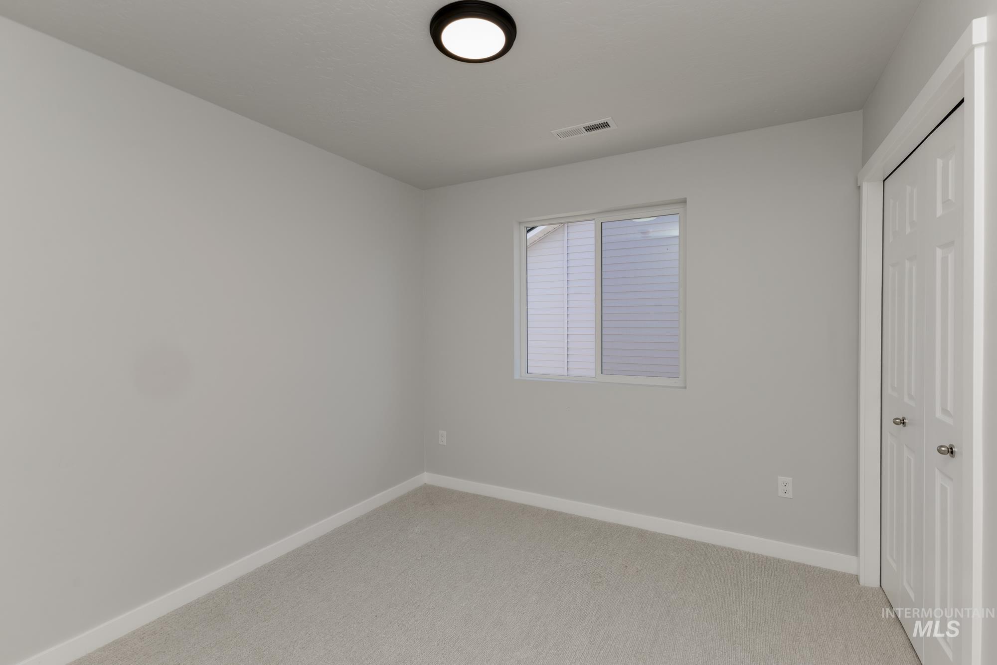 Unfurnished bedroom with a closet and light carpet