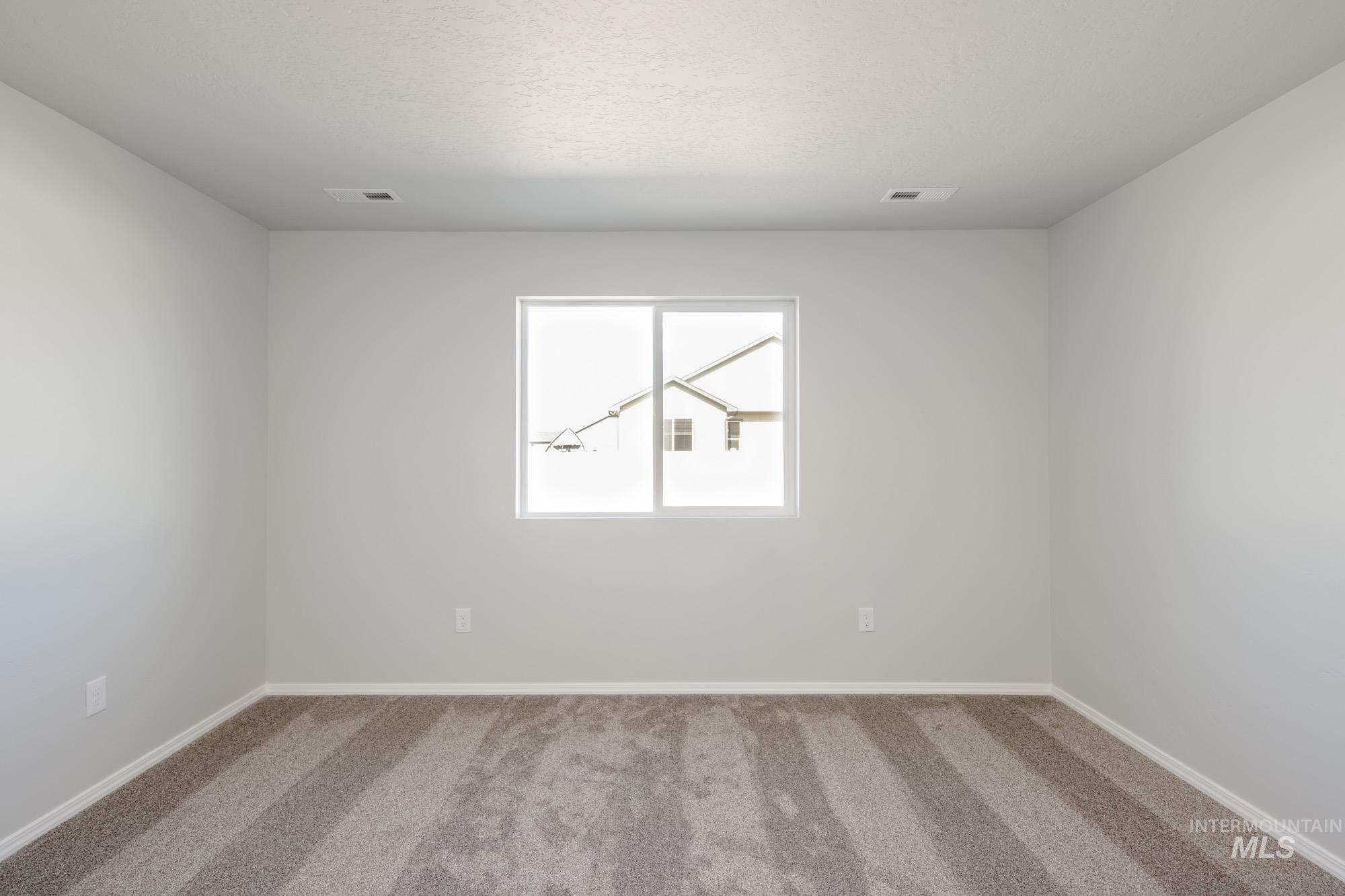 Empty room featuring carpet flooring and baseboards