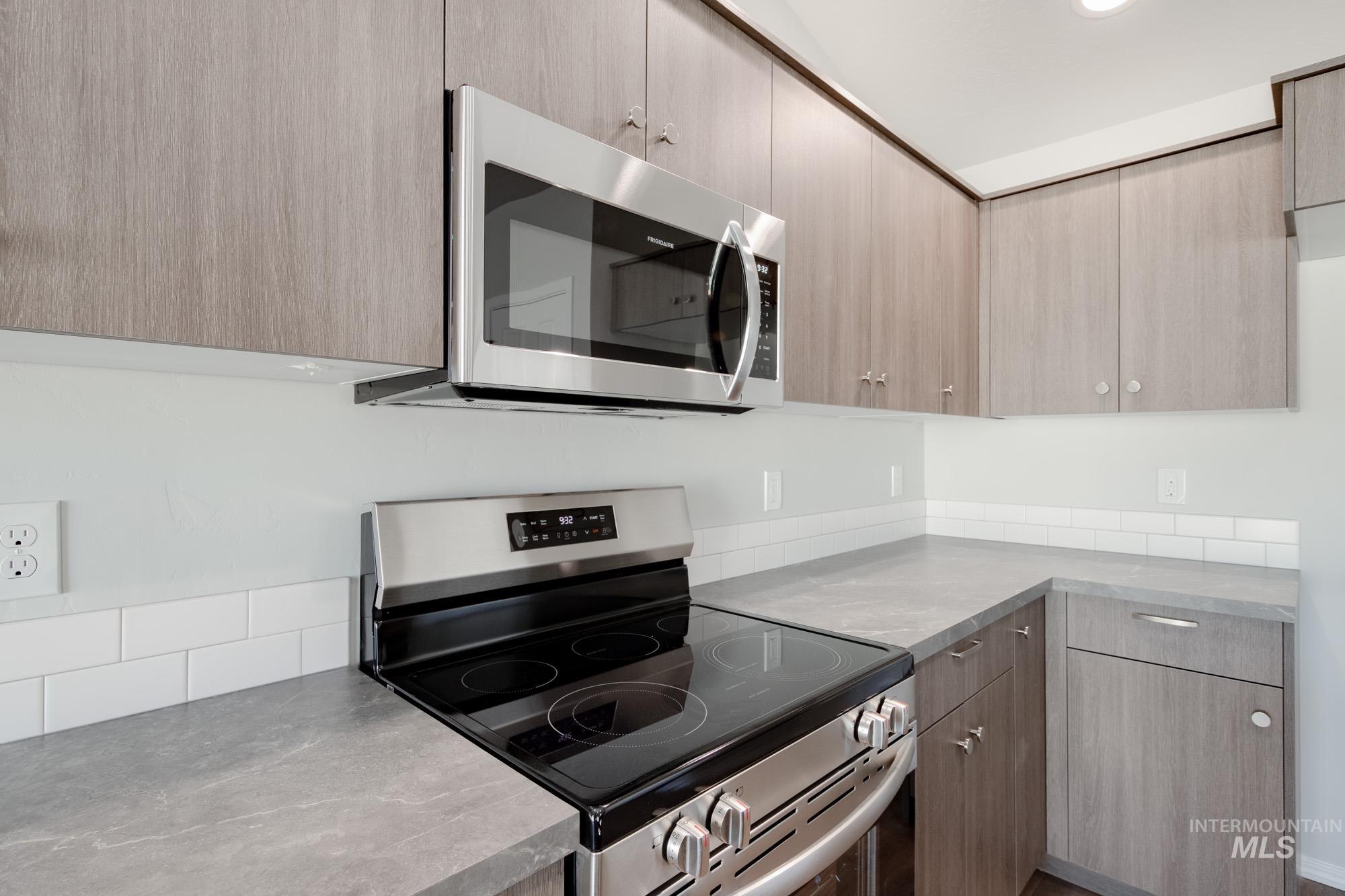 Kitchen featuring appliances with stainless steel finishes, modern cabinets, light brown cabinetry, and recessed lighting