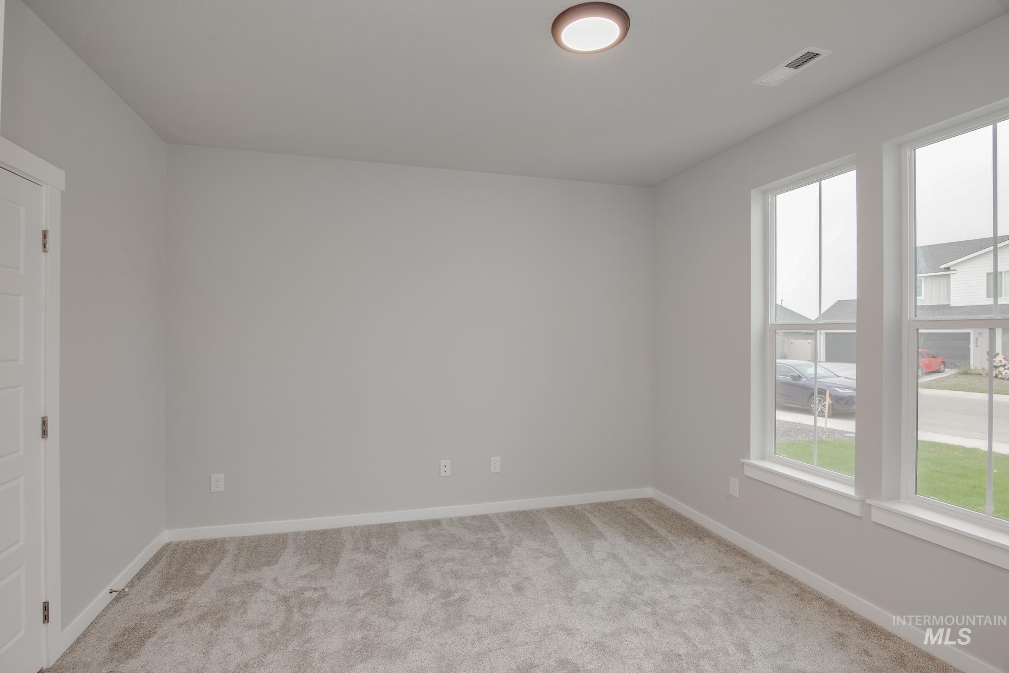 Unfurnished room with light colored carpet and baseboards