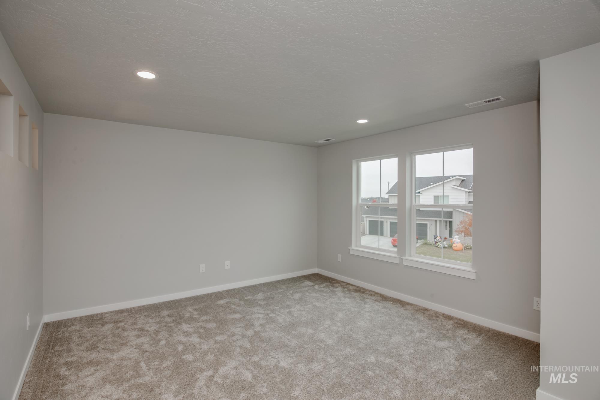 Spare room featuring carpet, recessed lighting, and a textured ceiling
