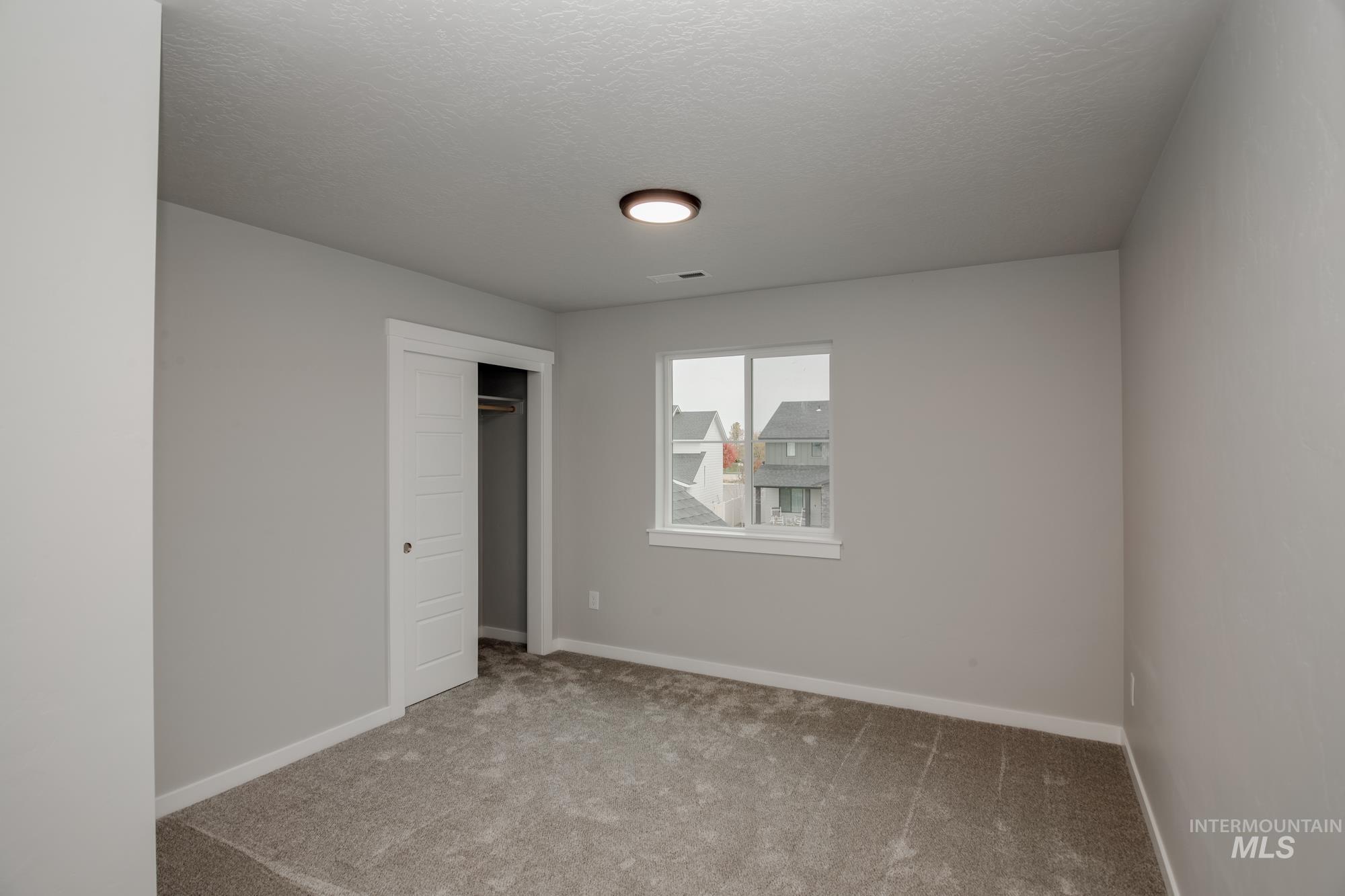 Unfurnished bedroom with carpet flooring, a closet, and a textured ceiling