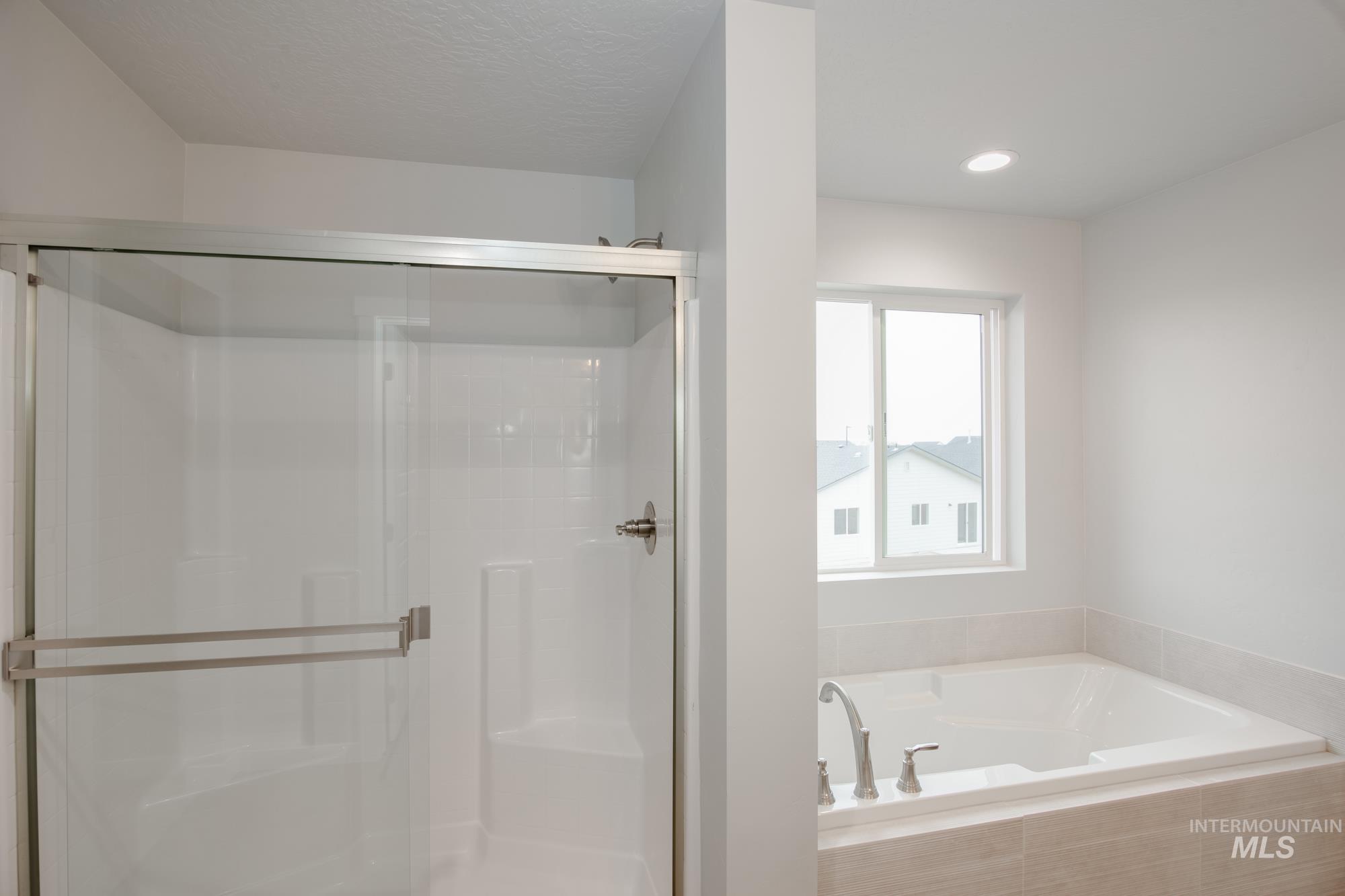 Full bathroom featuring a shower stall, a bath, and recessed lighting