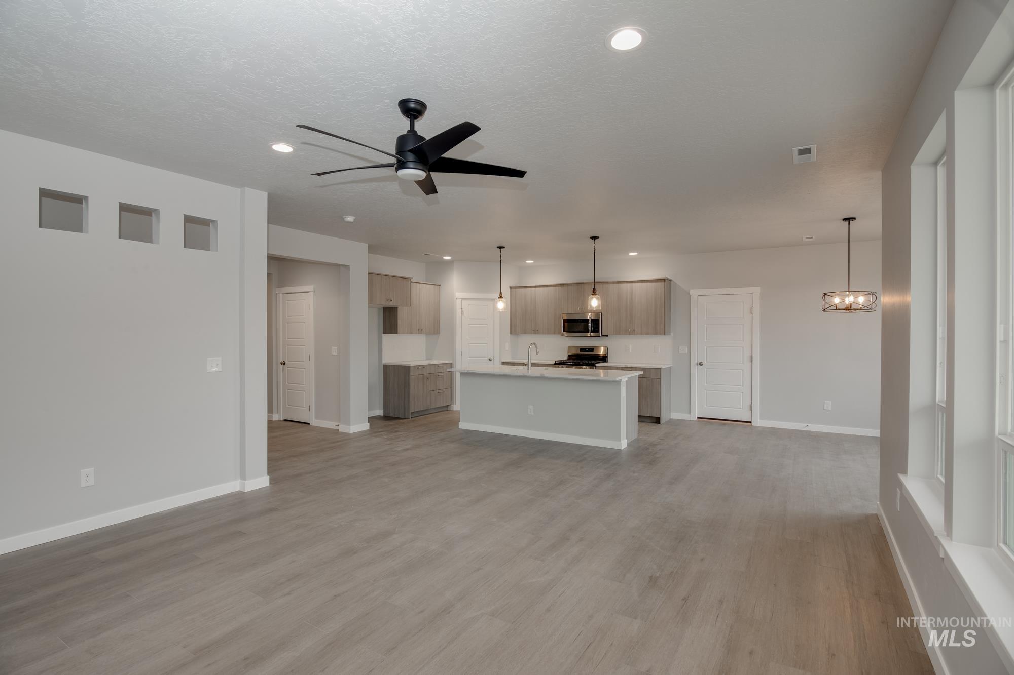Unfurnished living room featuring ceiling fan, light wood-style flooring, and recessed lighting