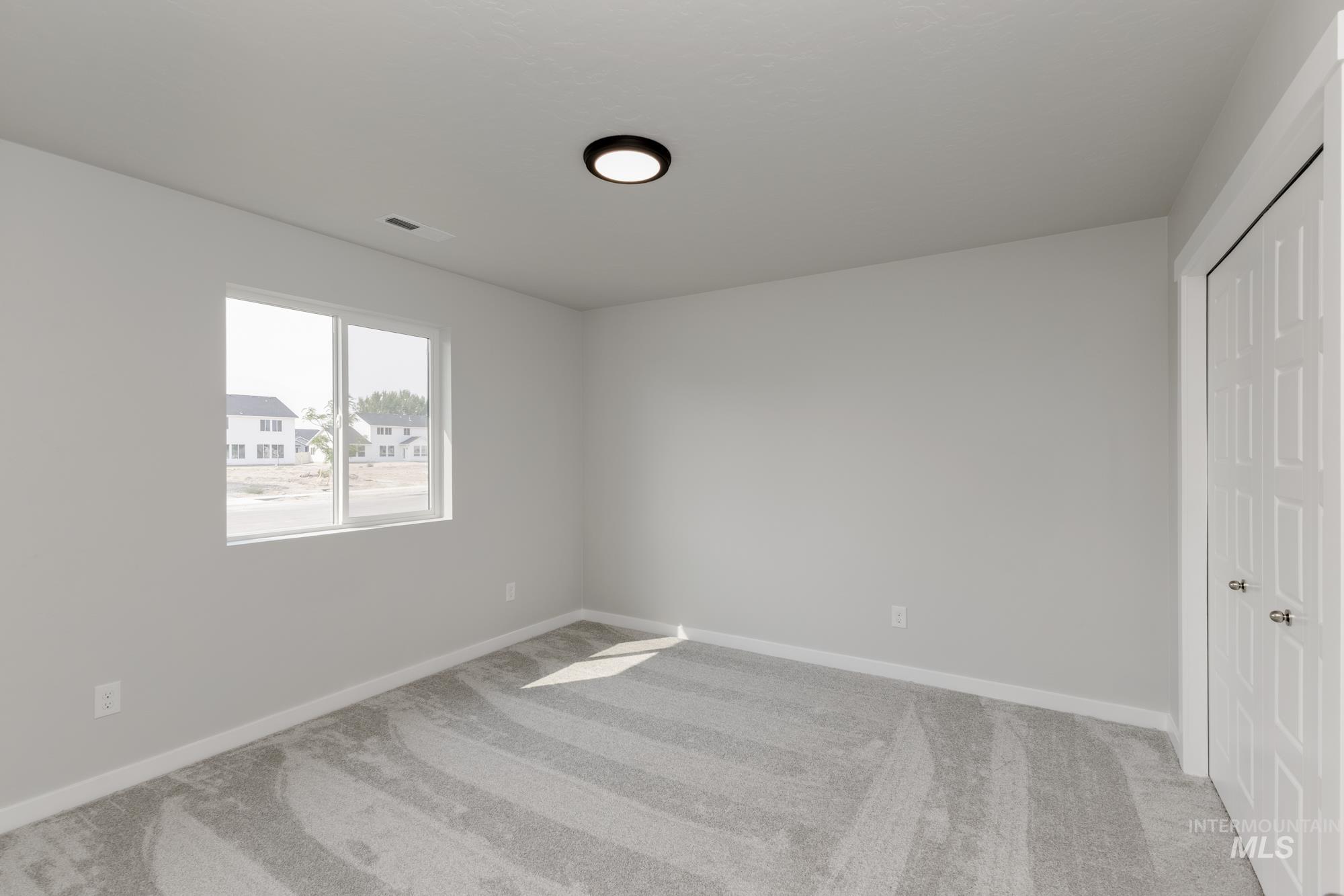 Unfurnished bedroom featuring light colored carpet and a closet