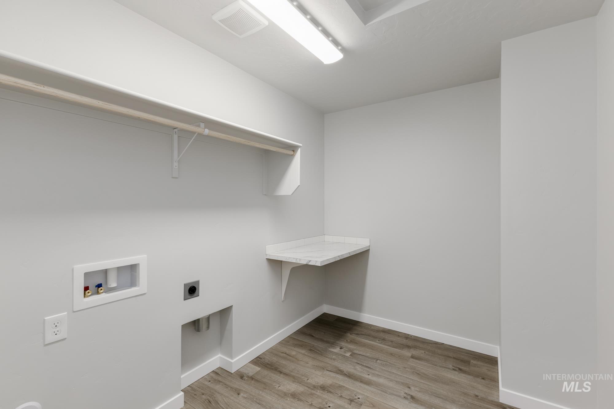 Laundry room featuring light wood-type flooring, washer hookup, and hookup for an electric dryer