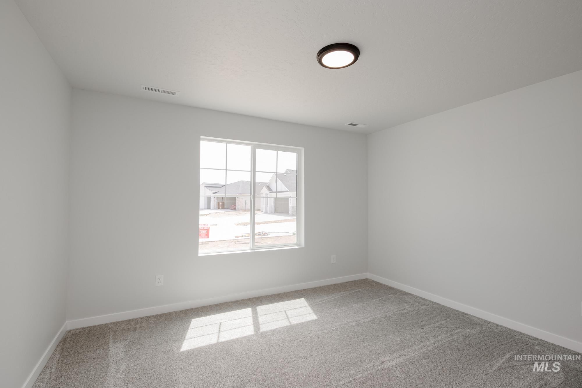 Empty room with light carpet and baseboards