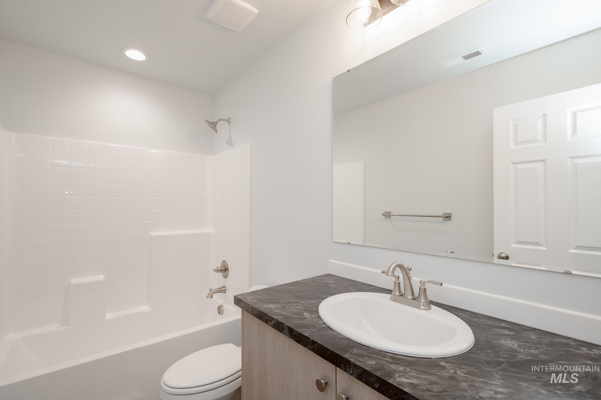 Full bathroom with shower / washtub combination, vanity, and recessed lighting