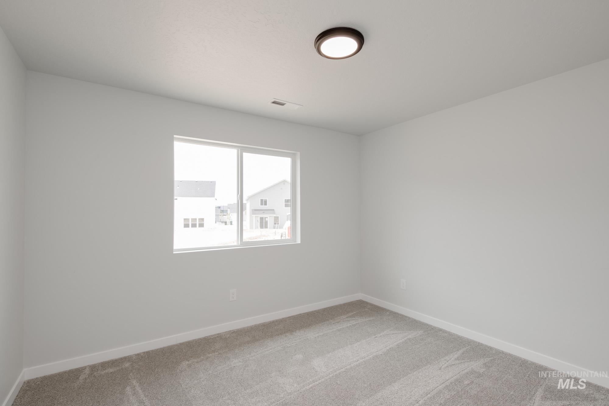 Carpeted empty room with baseboards