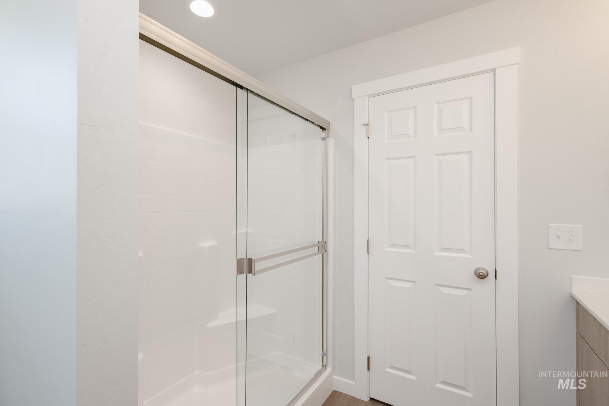 Full bathroom with vanity, a shower stall, and recessed lighting