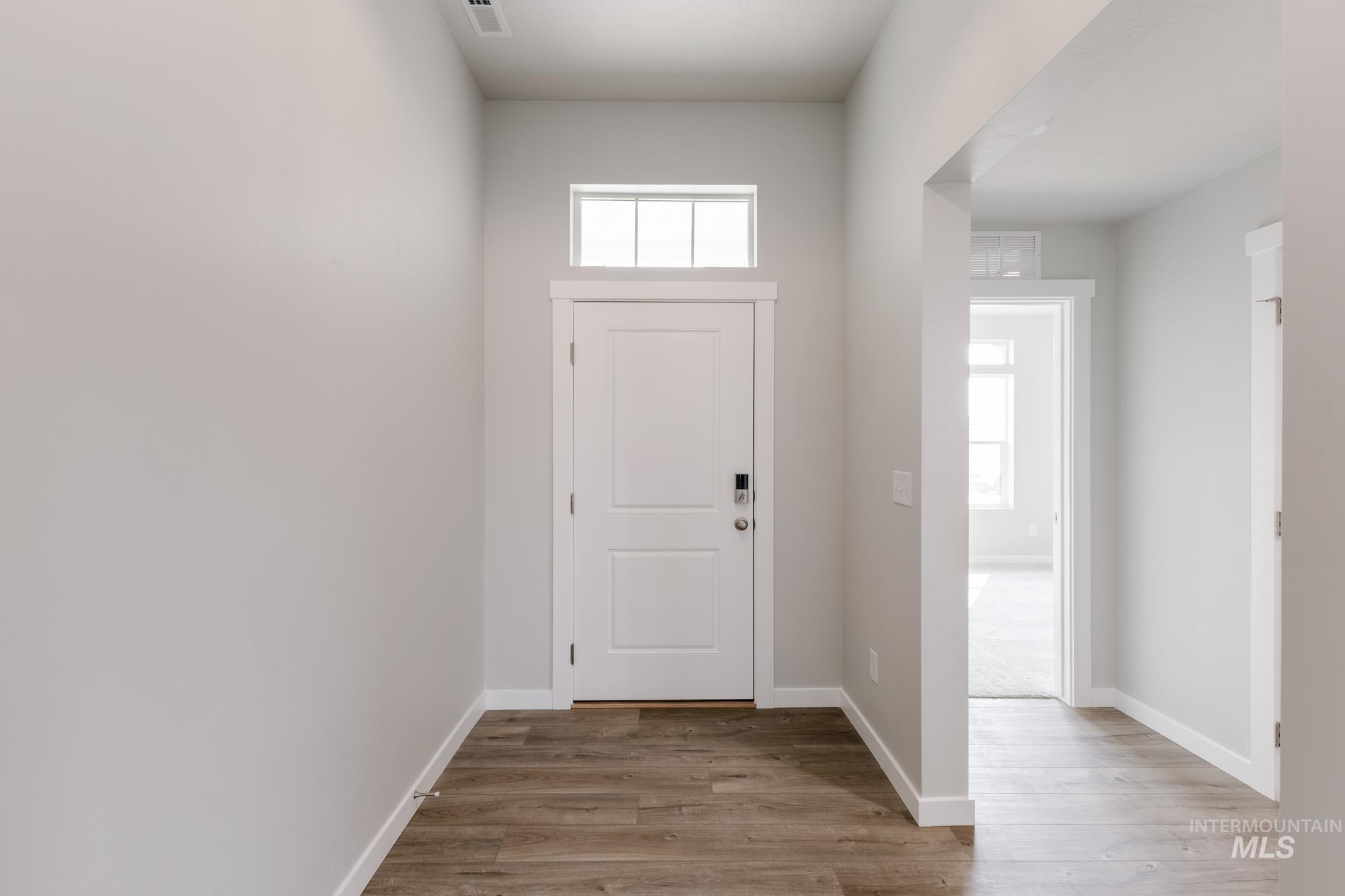 Foyer with light wood-style flooring and baseboards