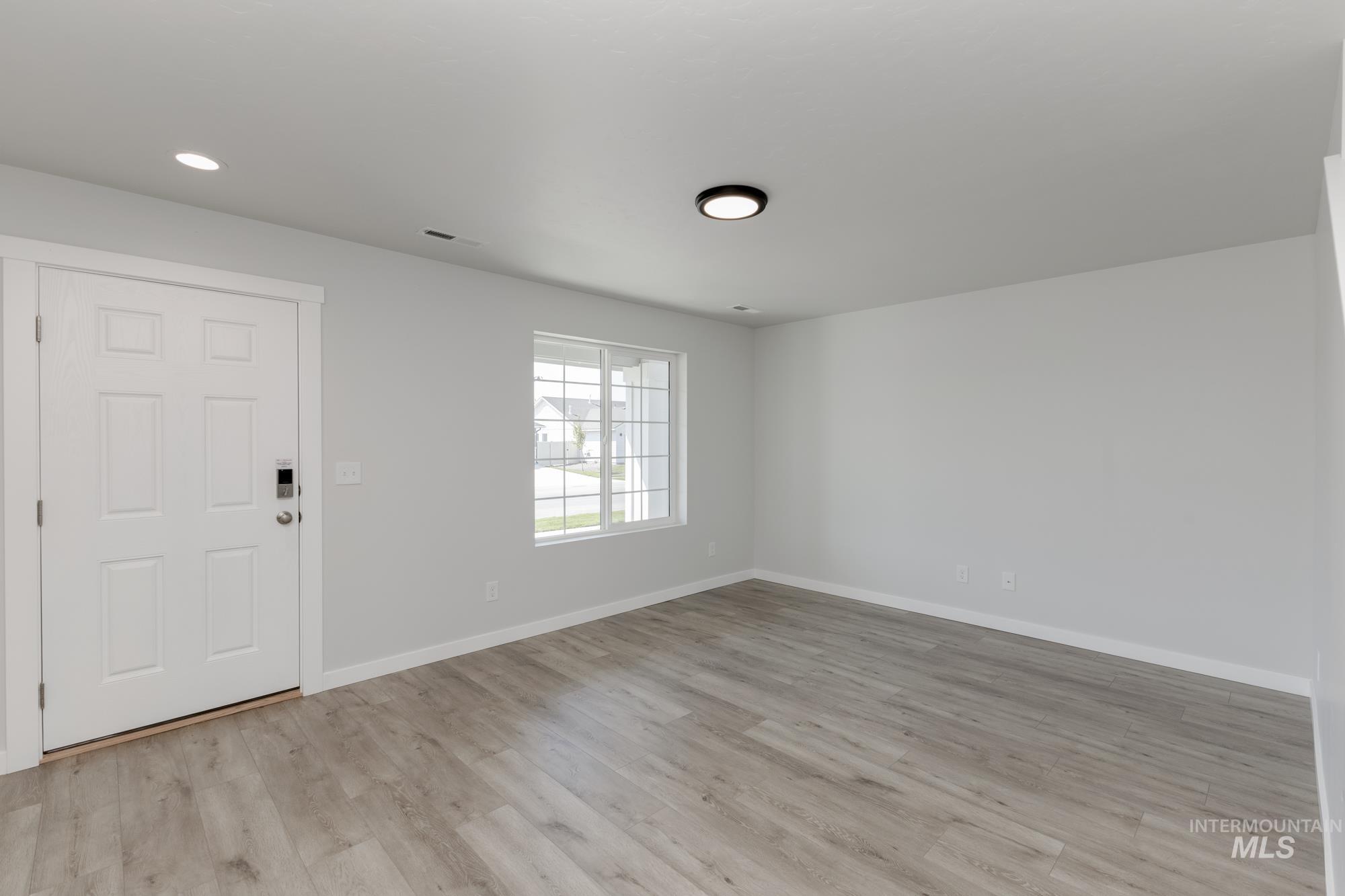 Entryway with light wood-style flooring and recessed lighting