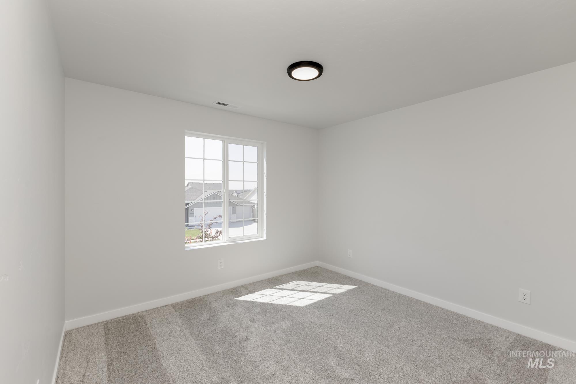 Carpeted empty room featuring baseboards