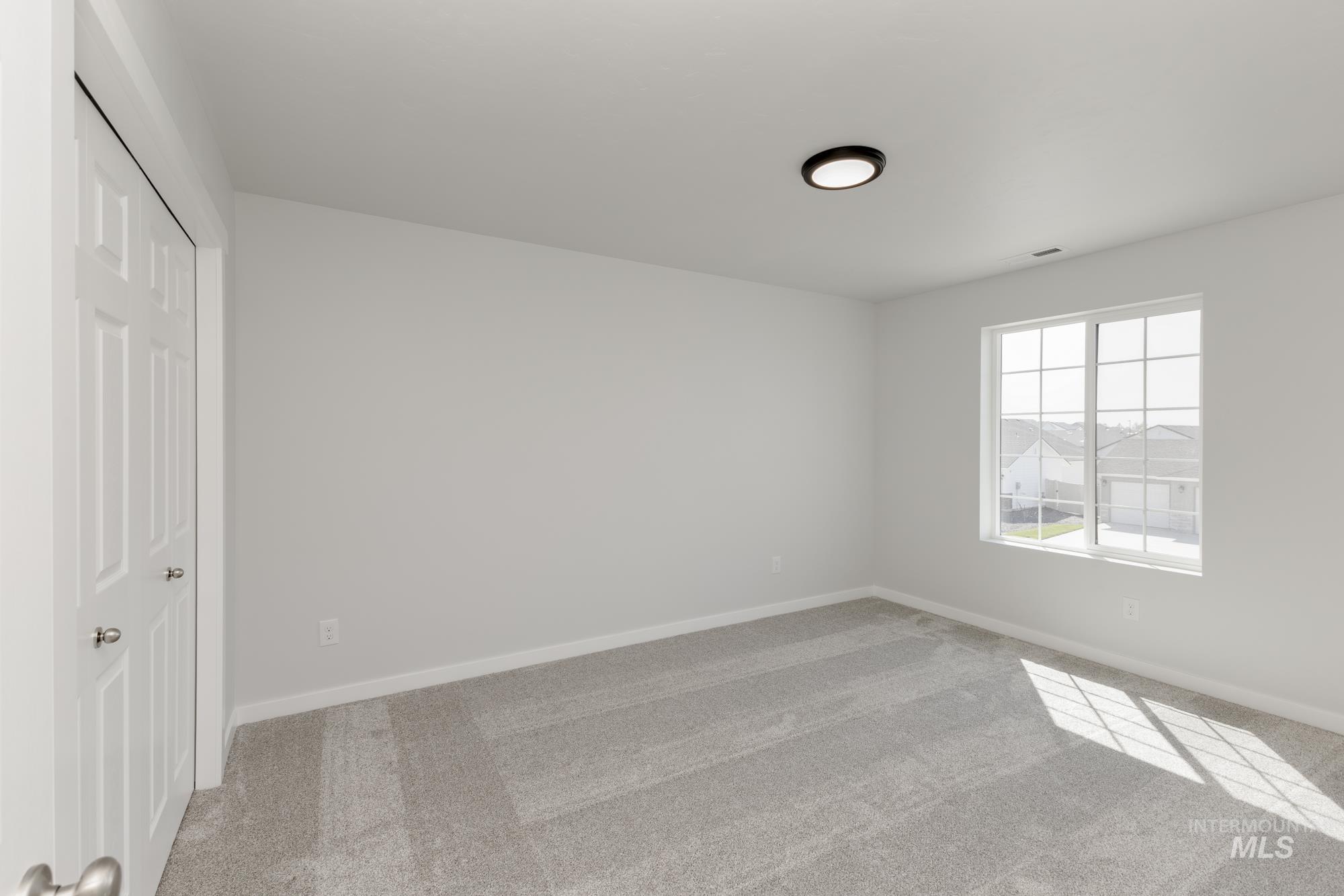 Unfurnished bedroom with light carpet and a closet