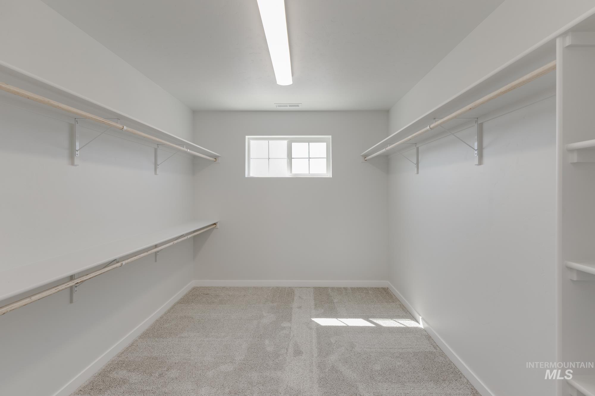 Spacious closet with light colored carpet