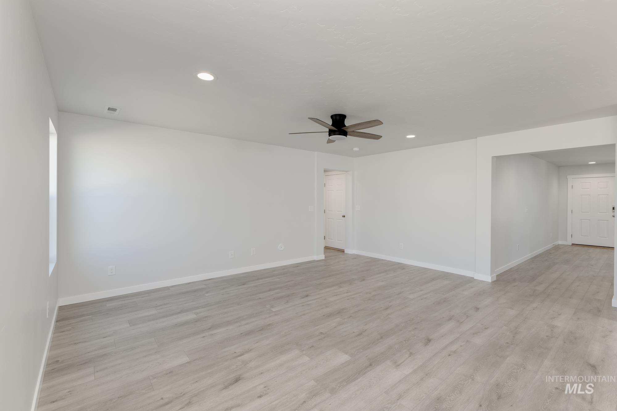 Empty room featuring light wood-type flooring, recessed lighting, and a ceiling fan