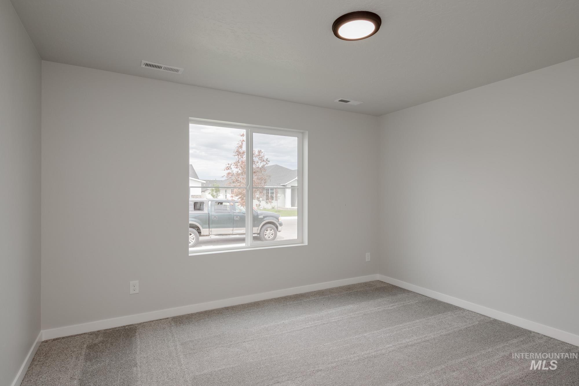 Spare room with light carpet and baseboards