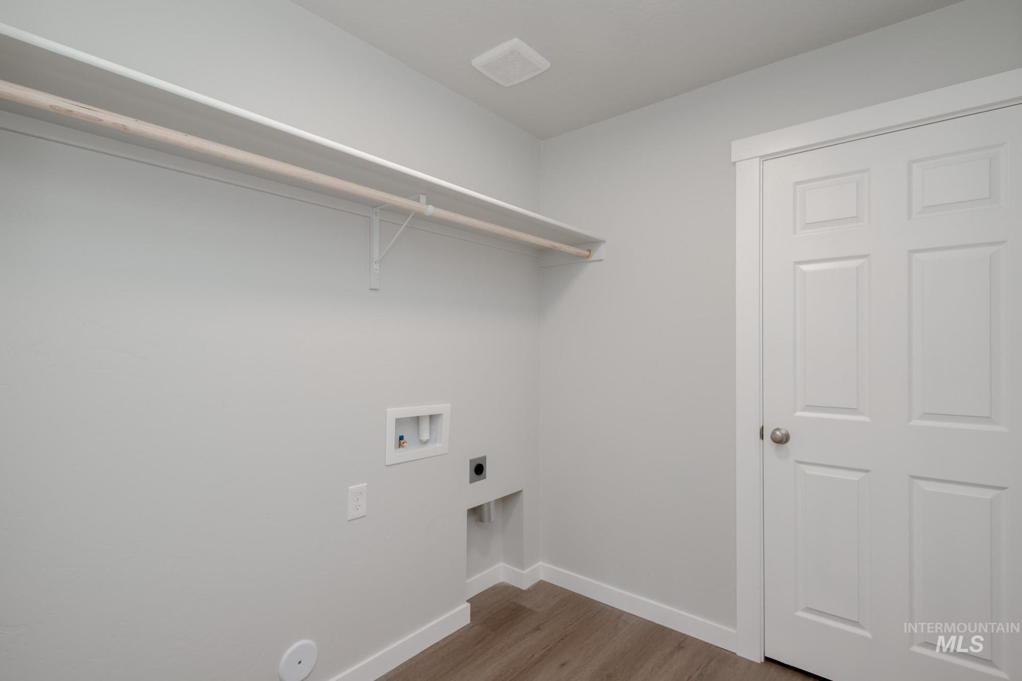 Laundry area with light wood finished floors, washer hookup, and electric dryer hookup