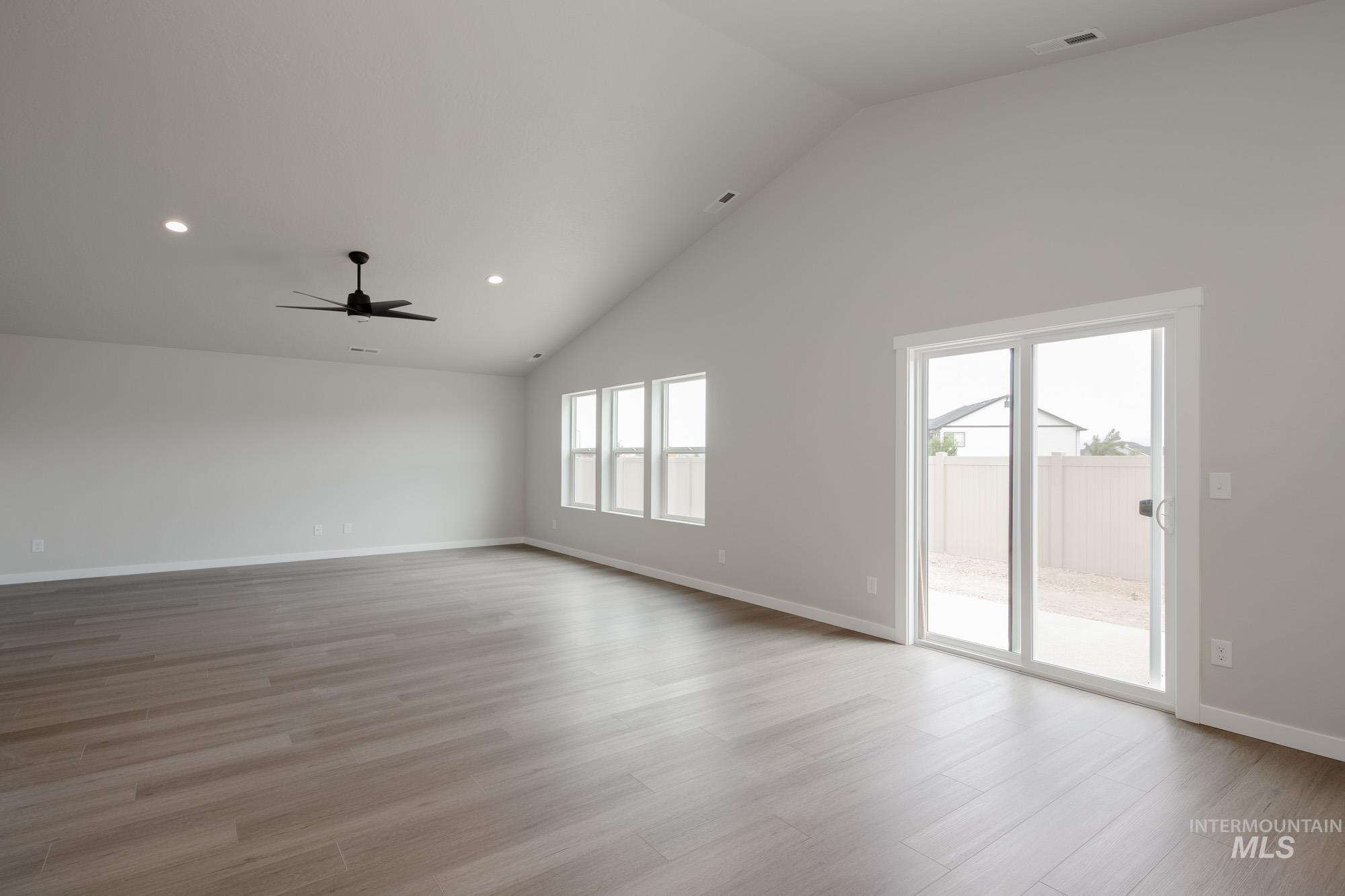 Unfurnished room featuring high vaulted ceiling, recessed lighting, light wood-style floors, and ceiling fan