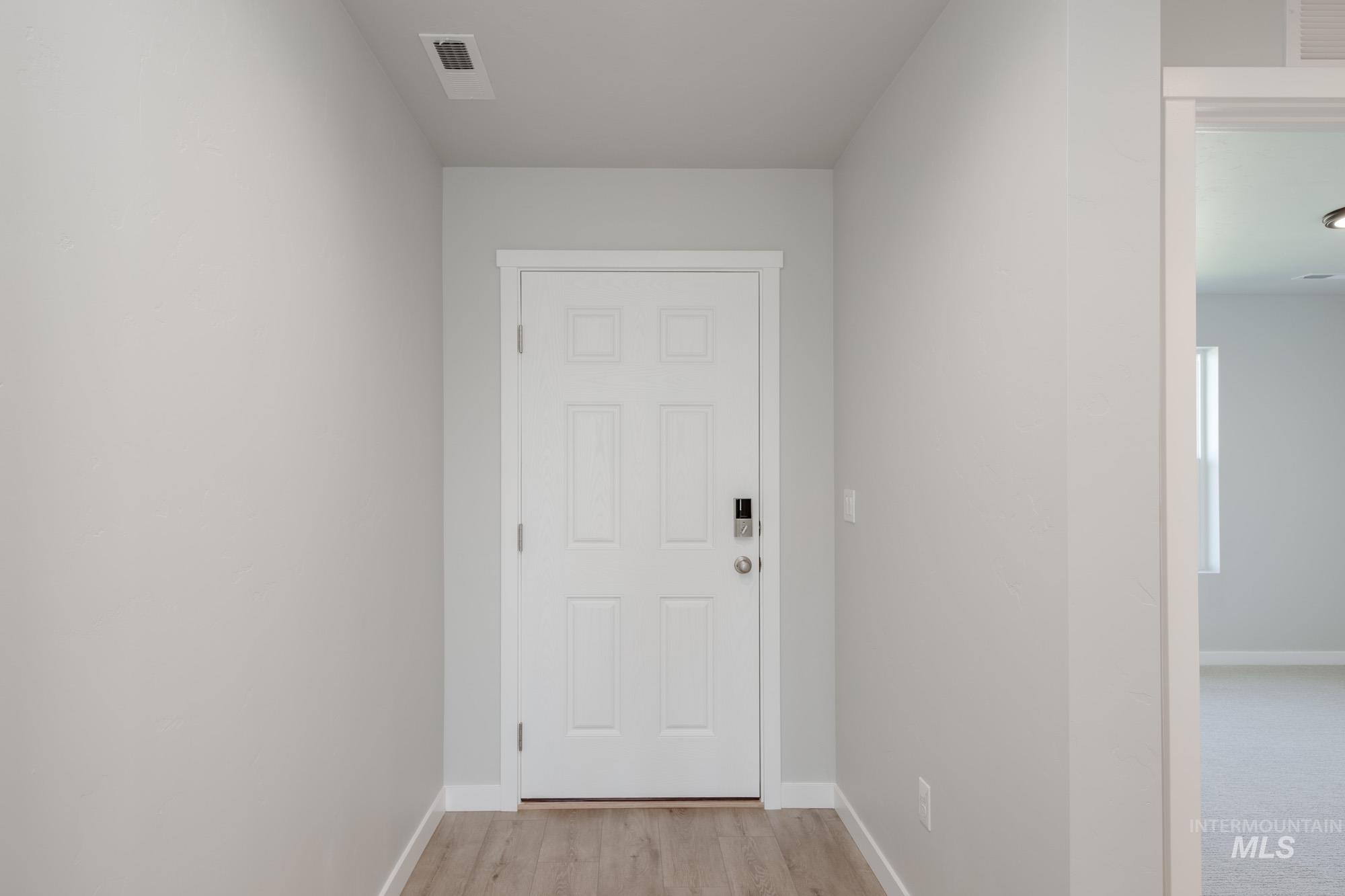 Doorway to outside with baseboards and wood finished floors