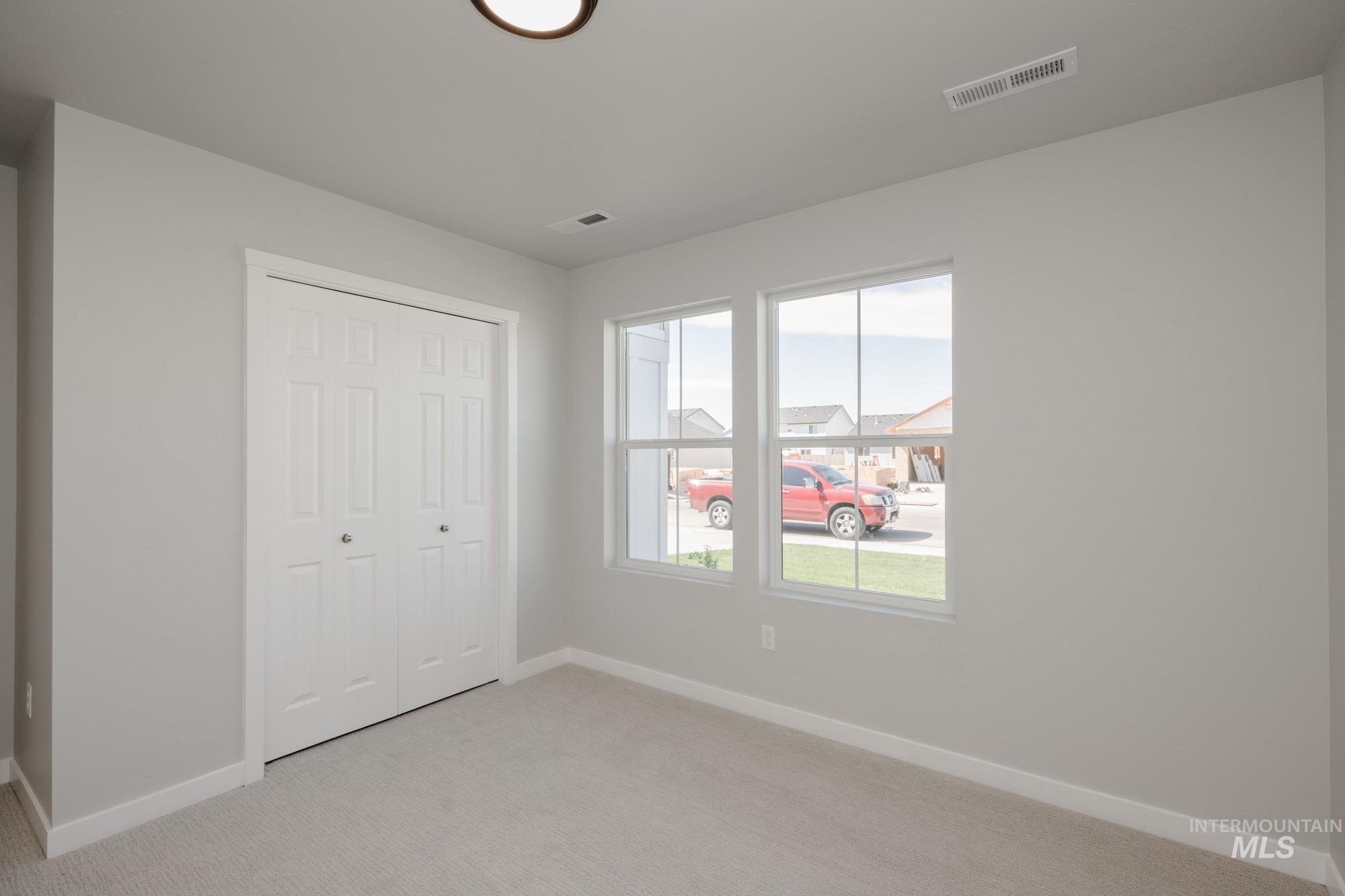 Unfurnished bedroom featuring light colored carpet and a closet