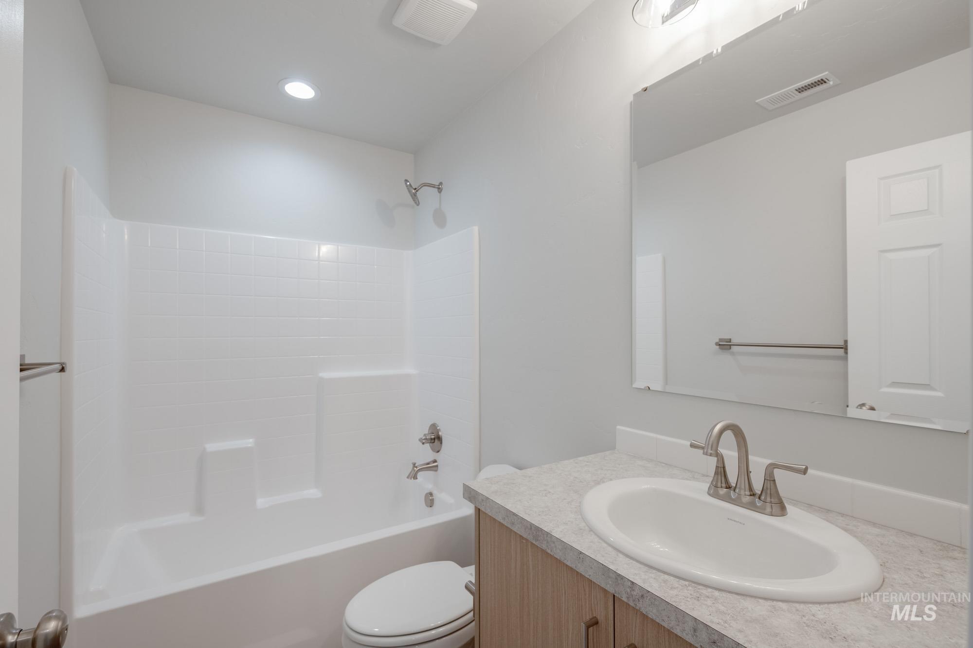 Full bath featuring bathtub / shower combination, vanity, and recessed lighting