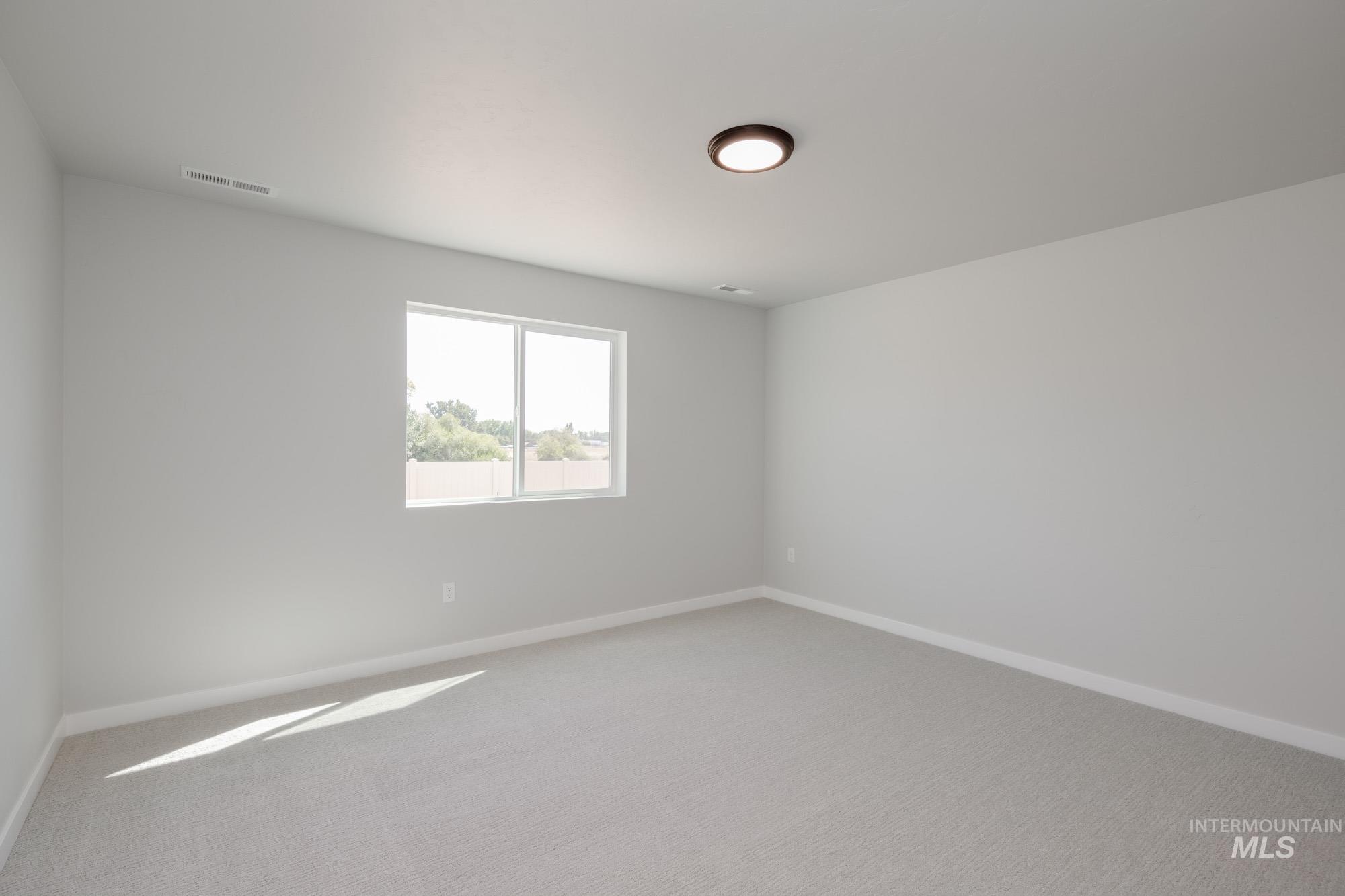 Spare room with light carpet and baseboards