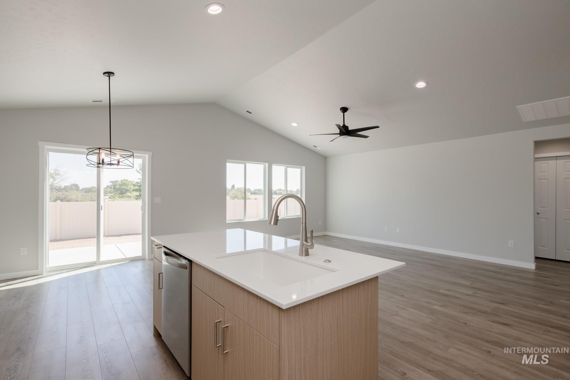 Kitchen featuring decorative light fixtures, light wood-style flooring, open floor plan, recessed lighting, and lofted ceiling