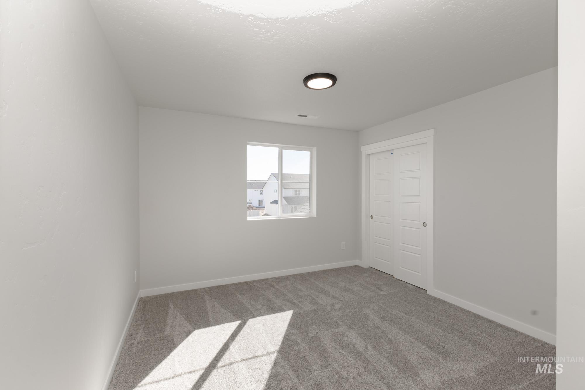 Spare room with carpet flooring and a textured ceiling