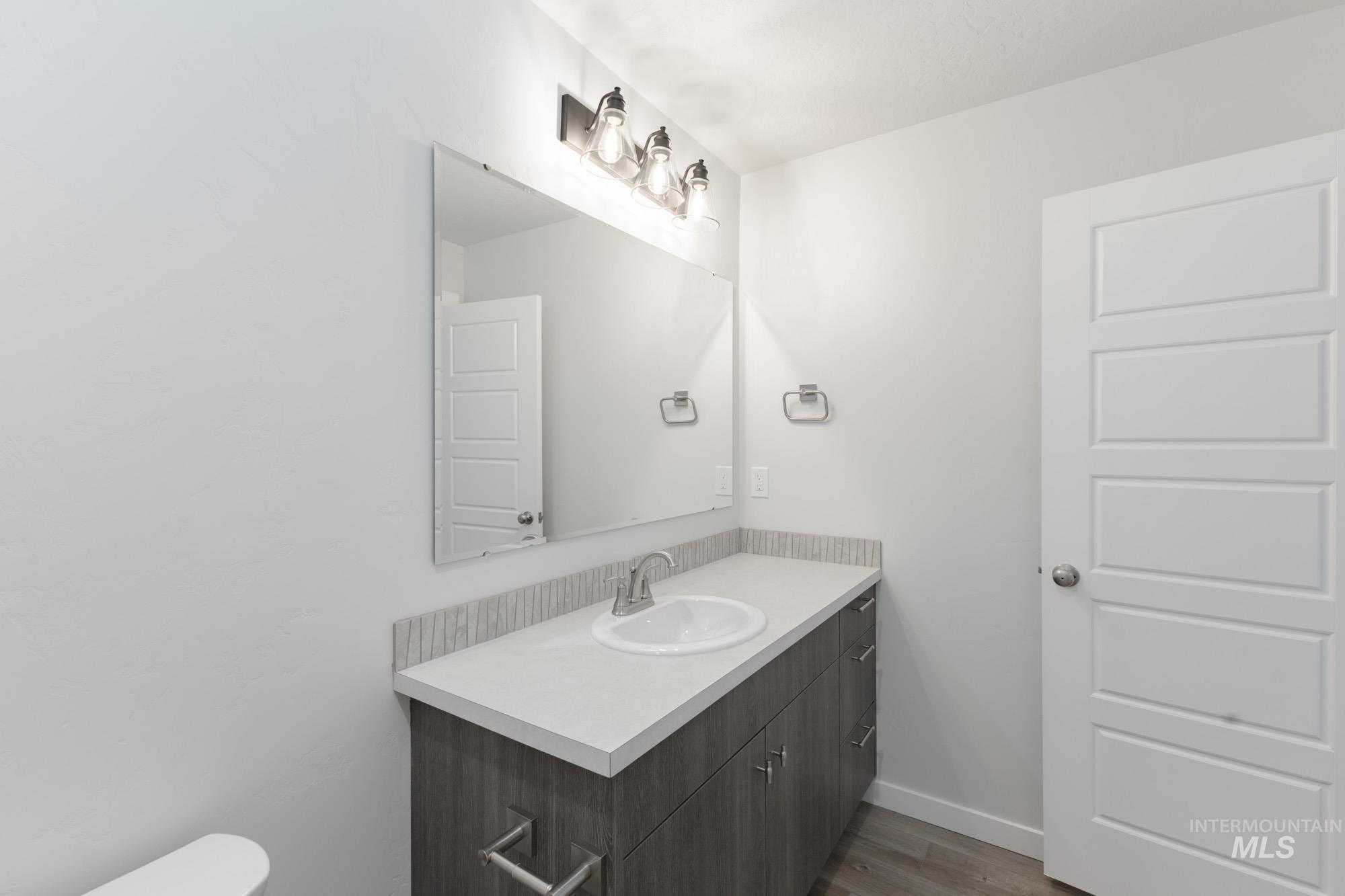 Bathroom with vanity and dark wood-style flooring