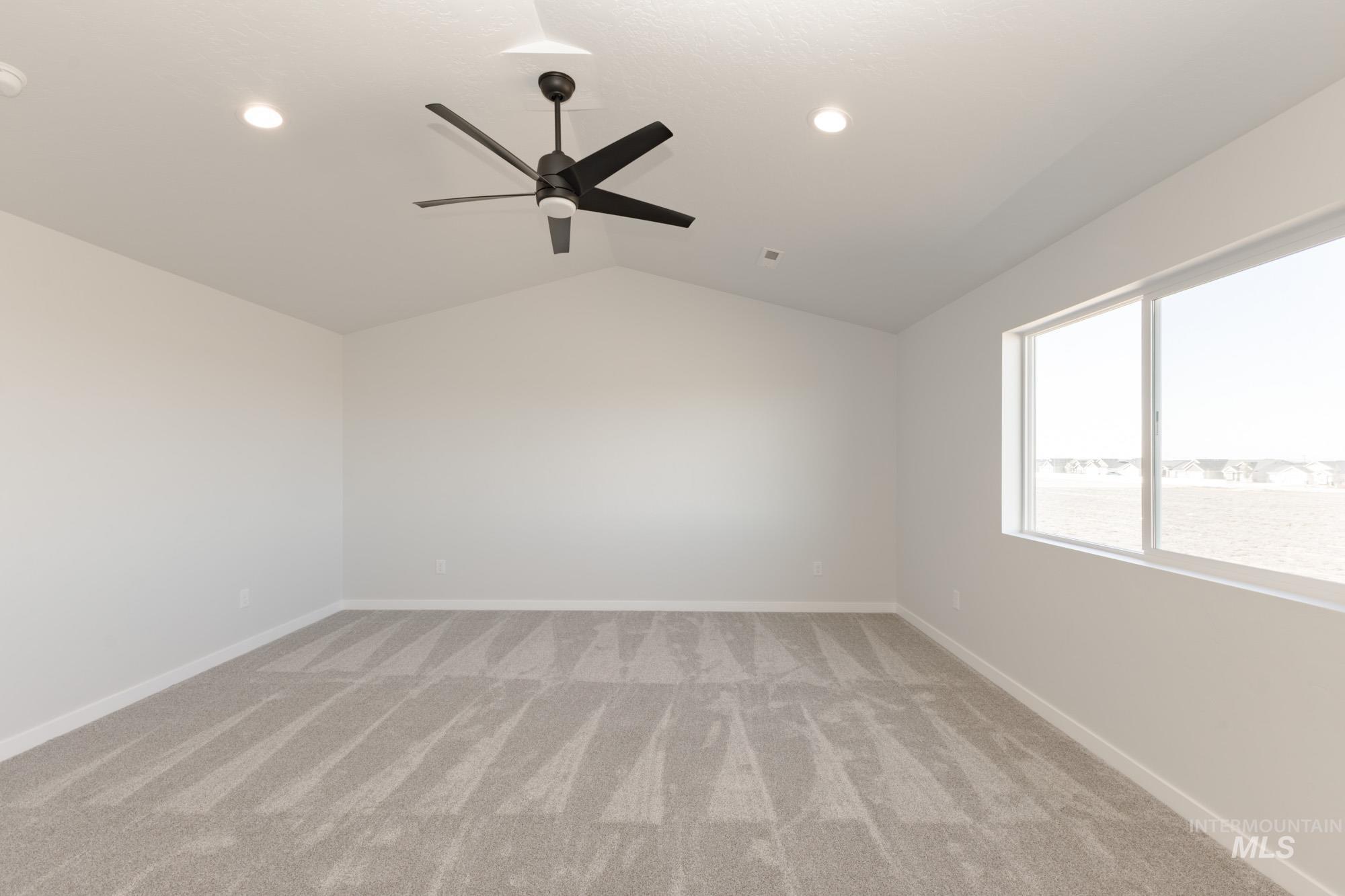 Empty room with lofted ceiling, light carpet, ceiling fan, and recessed lighting