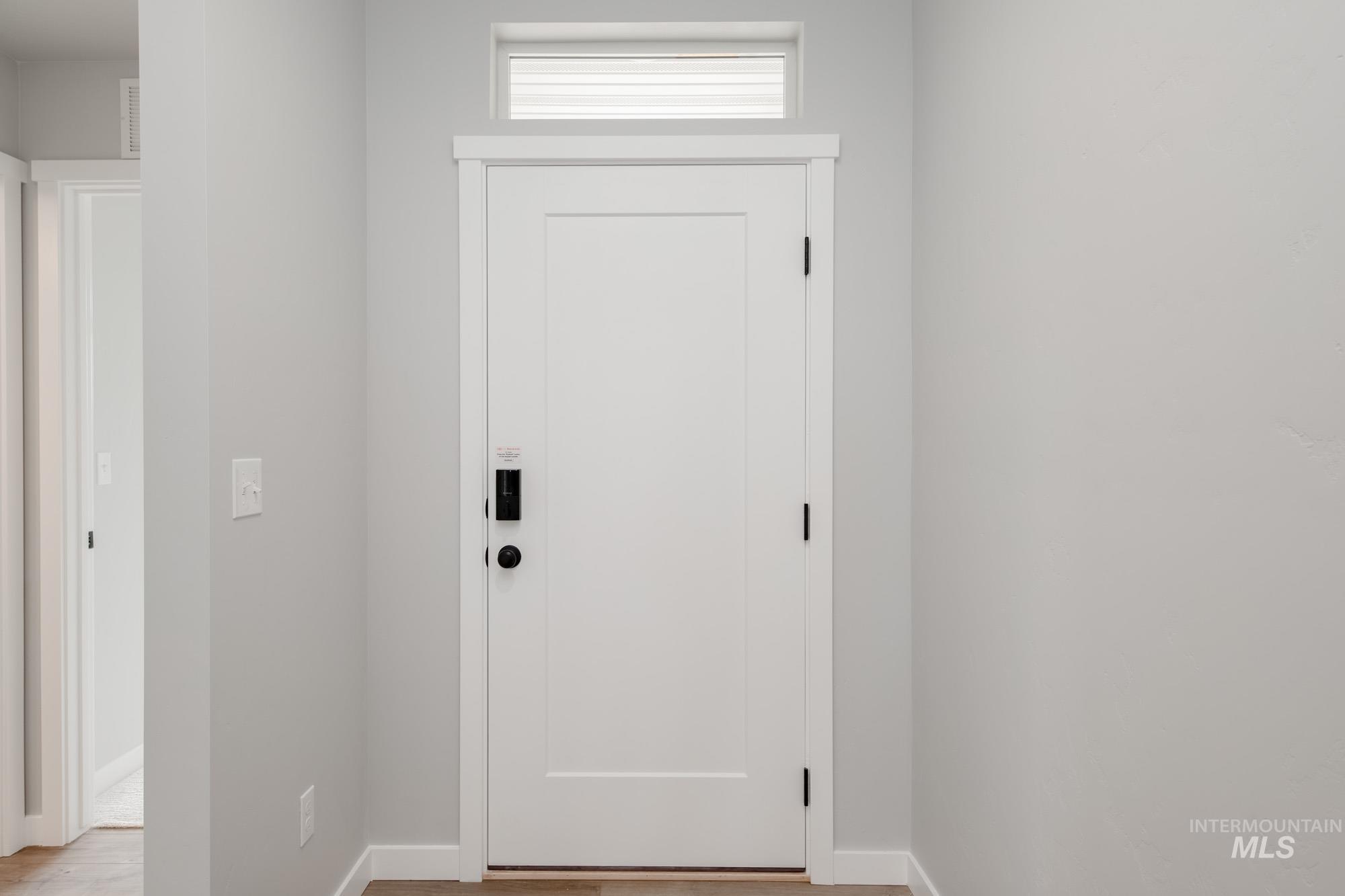 Doorway featuring baseboards and wood finished floors