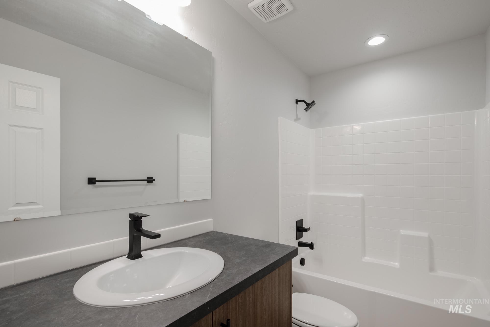Full bath with shower / tub combination, vanity, and recessed lighting