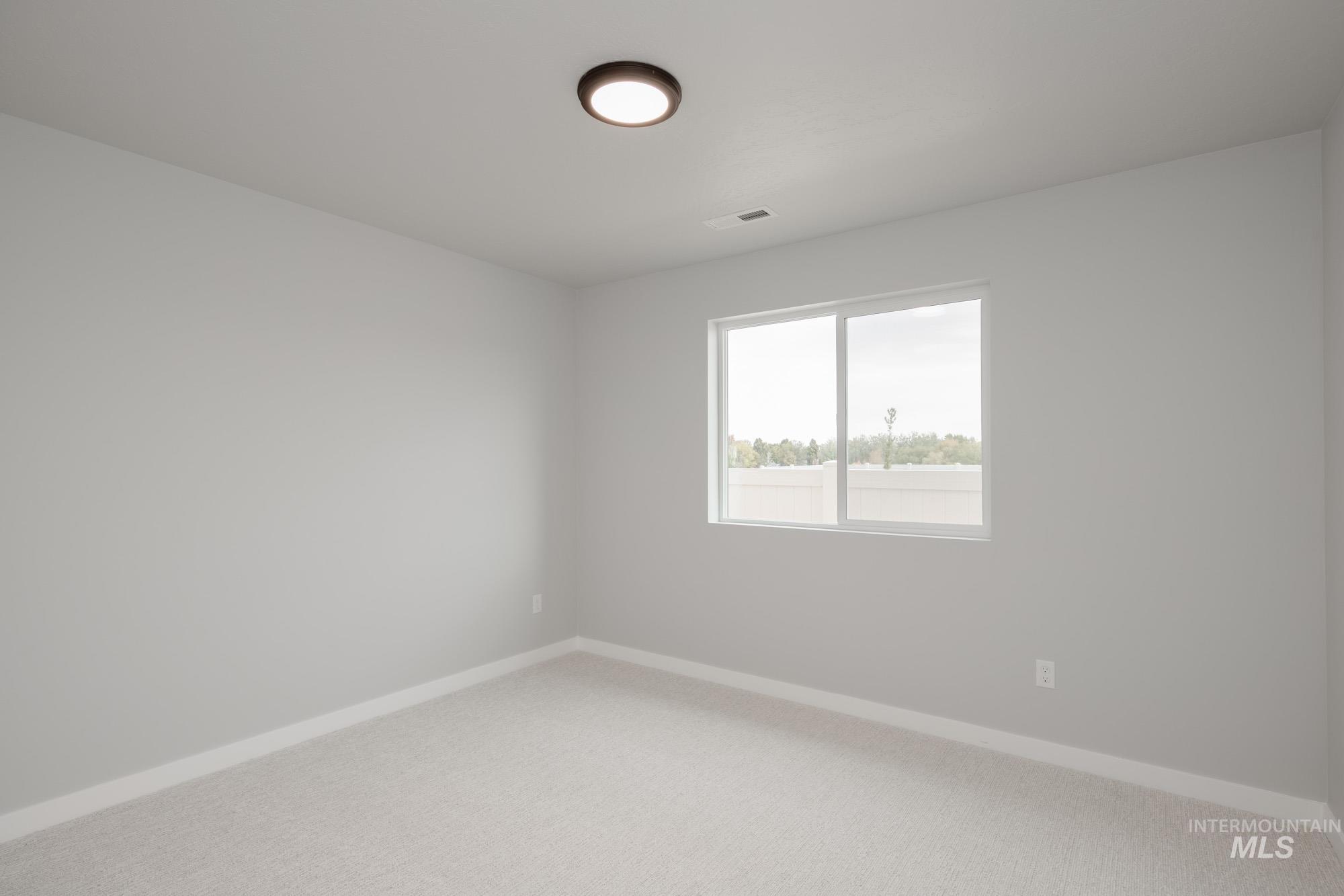 Spare room featuring baseboards and carpet flooring