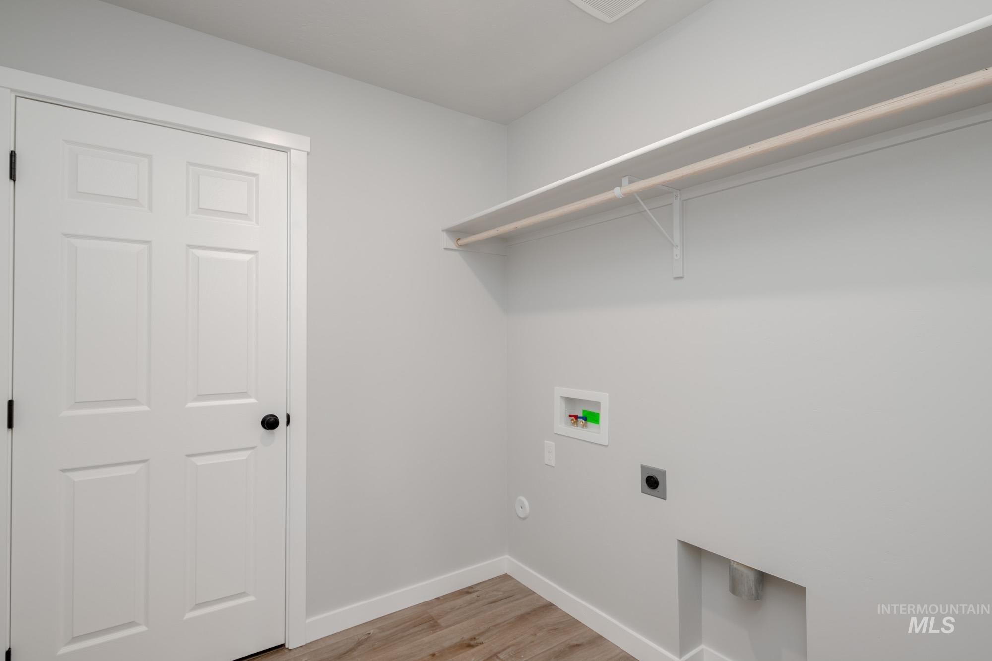 Laundry area featuring light wood-style floors, washer hookup, and hookup for an electric dryer